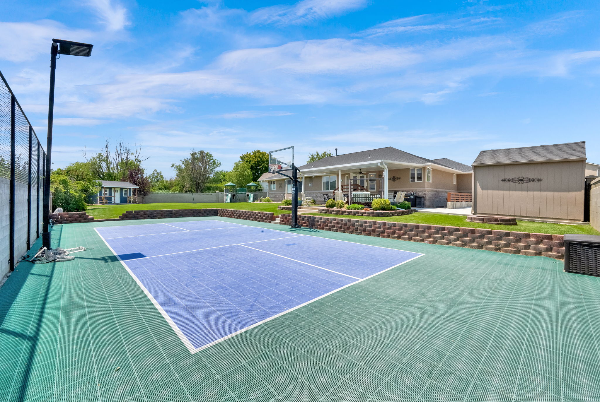 Multi-sport court with a basketball hoop and dedicated lighting