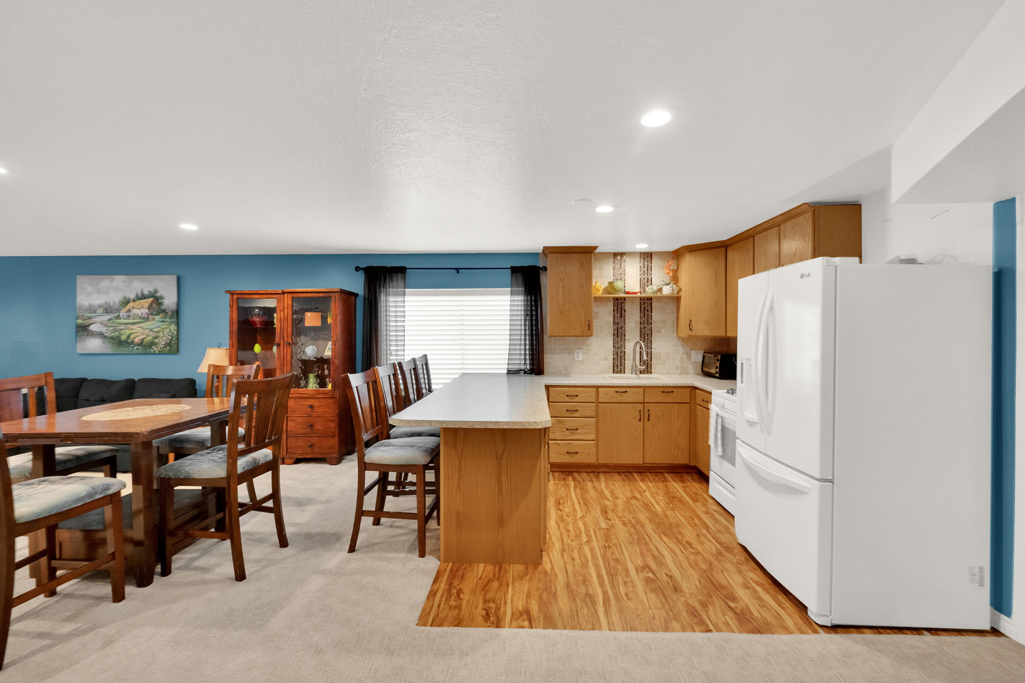 Kitchen and dining area featuring light wood-finish flooring, oak cabinetry, and a peninsula countertop