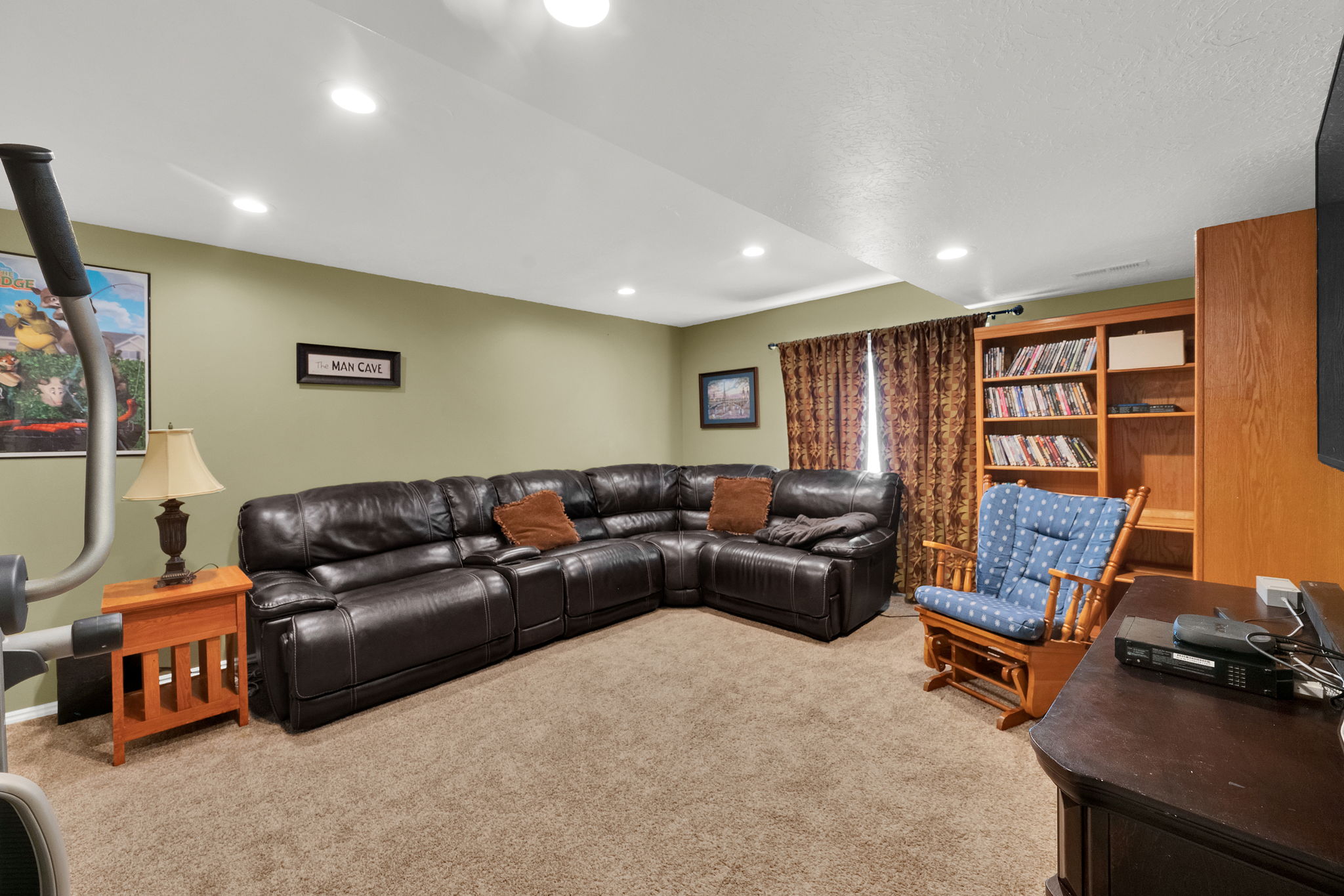 Spacious room featuring recessed lighting, soft green walls, and carpeting