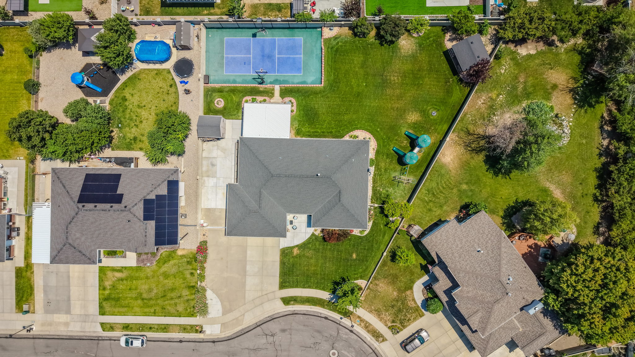 Expansive property featuring a tennis court, swimming pool, and multiple detached structures