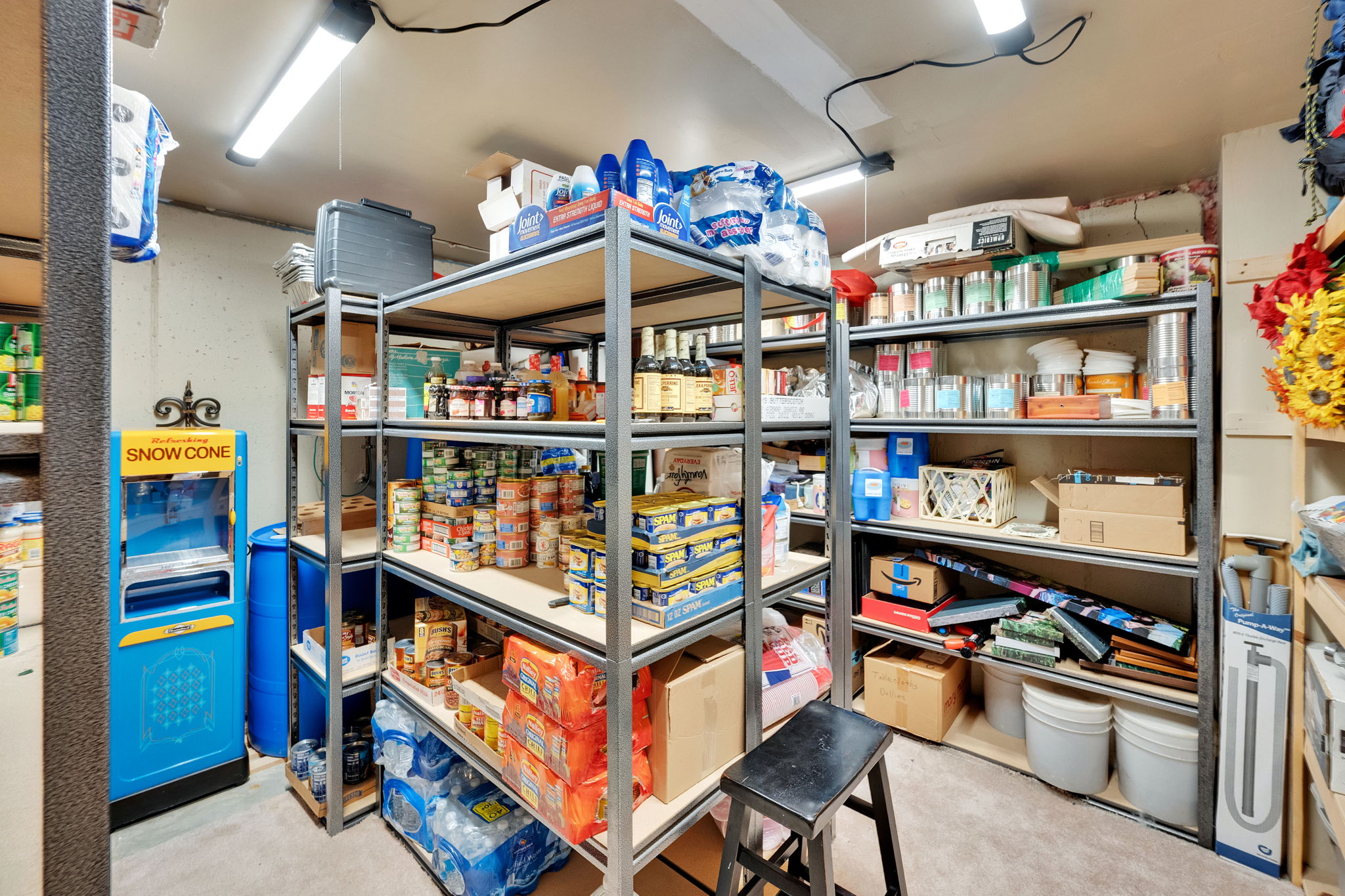 Utility room with multiple rows of metal shelving for extensive storage