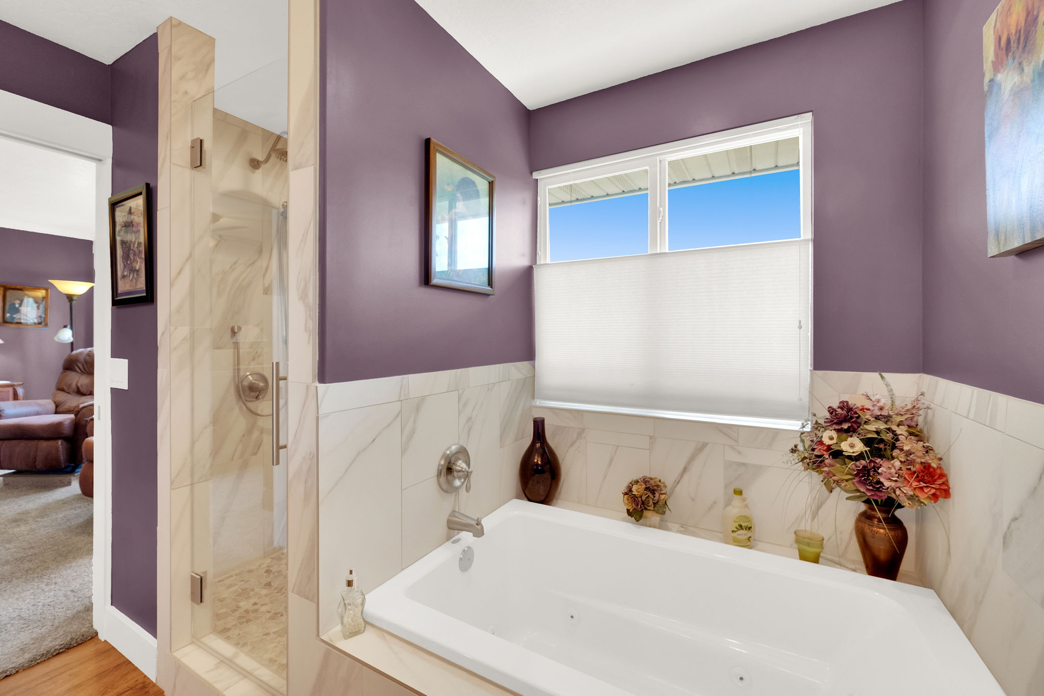 Soaking tub with jetted features, surrounded by marble-finish tile
