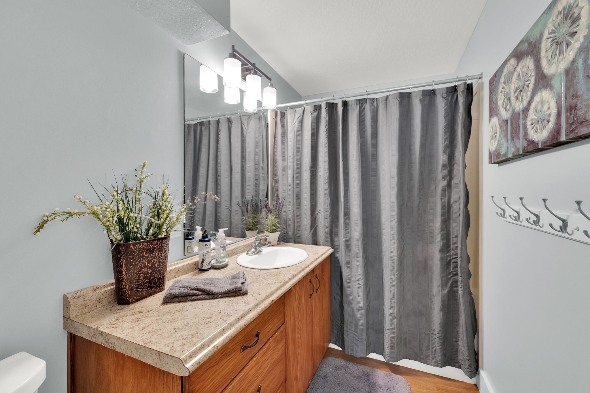 Bathroom vanity featuring a light-colored countertop, integrated sink, and wood-finish cabinetry