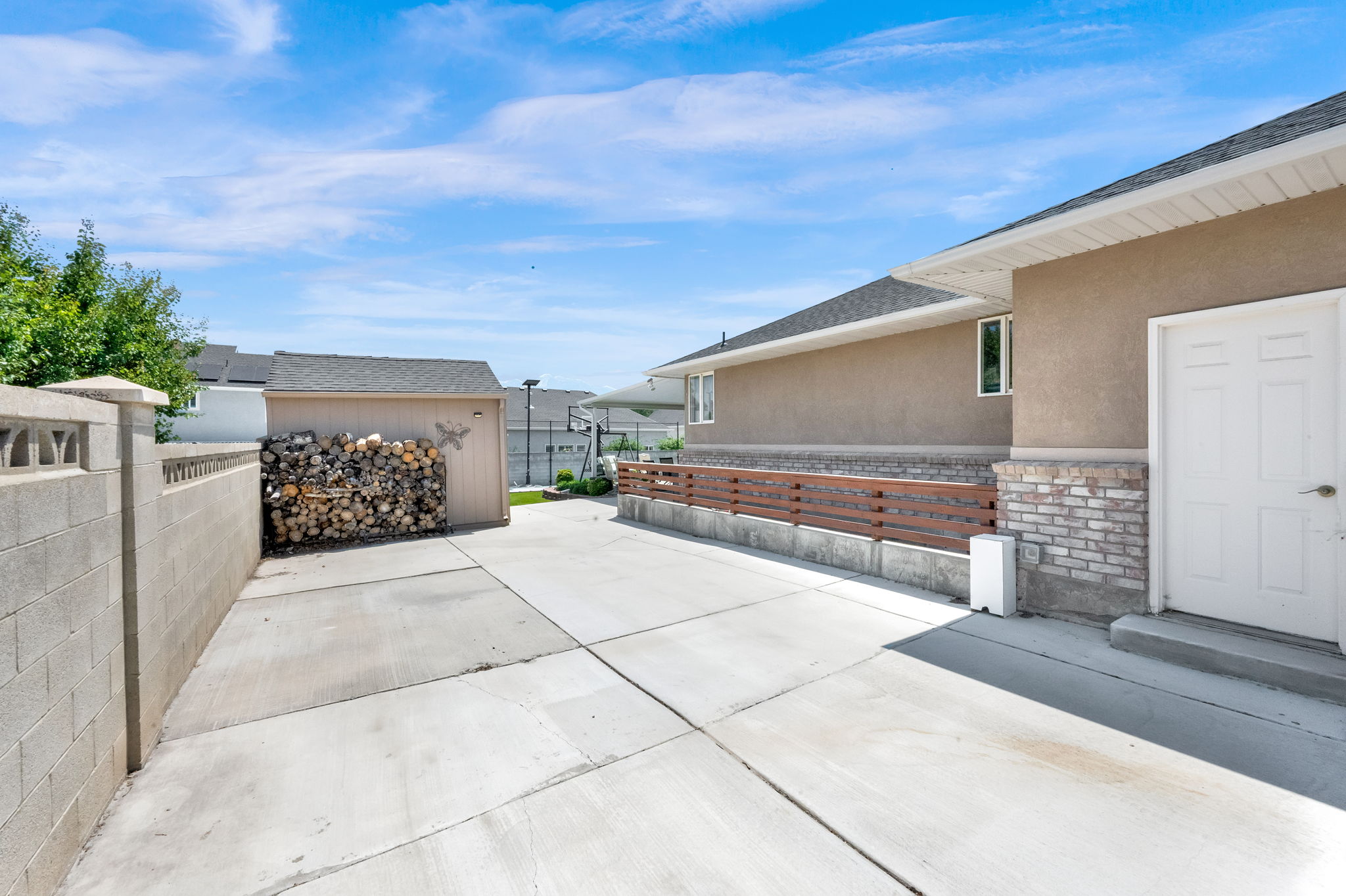 Concrete driveway providing access to a stucco and brick-clad residence
