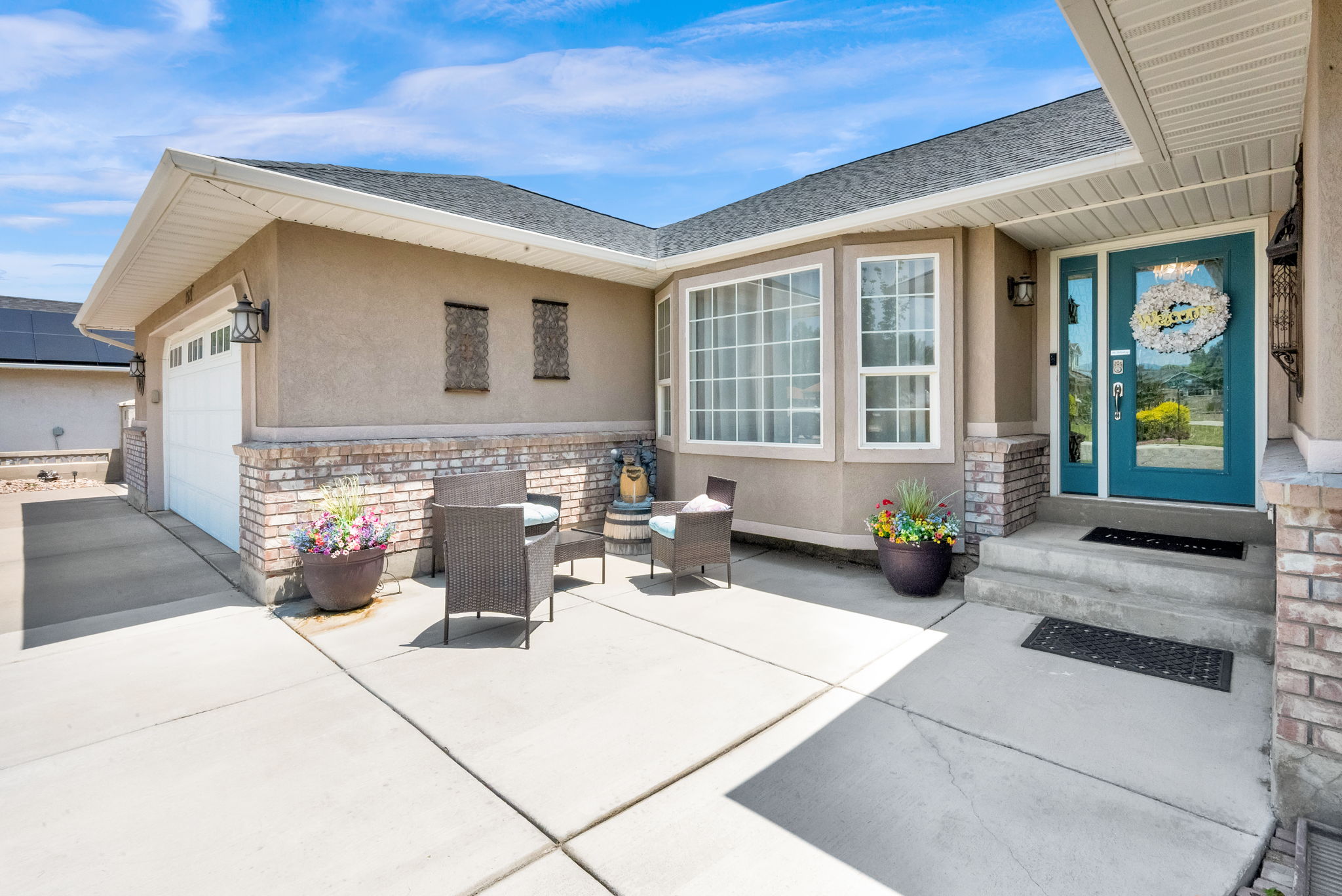 Warm stucco exterior with brick accents and a prominent turquoise entry door