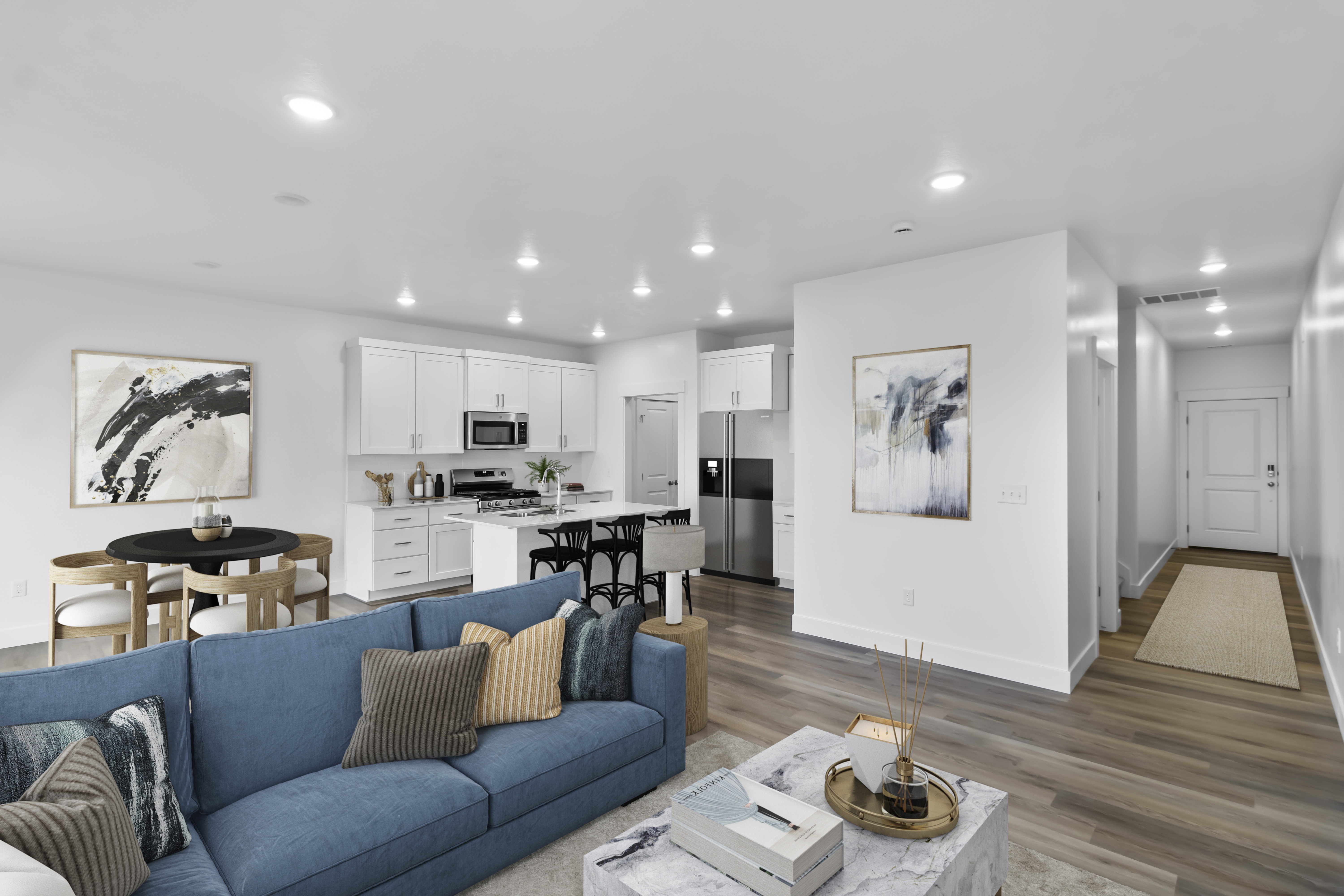 Open concept living area featuring wood-finish flooring, recessed lighting, and a modern kitchen with white cabinetry