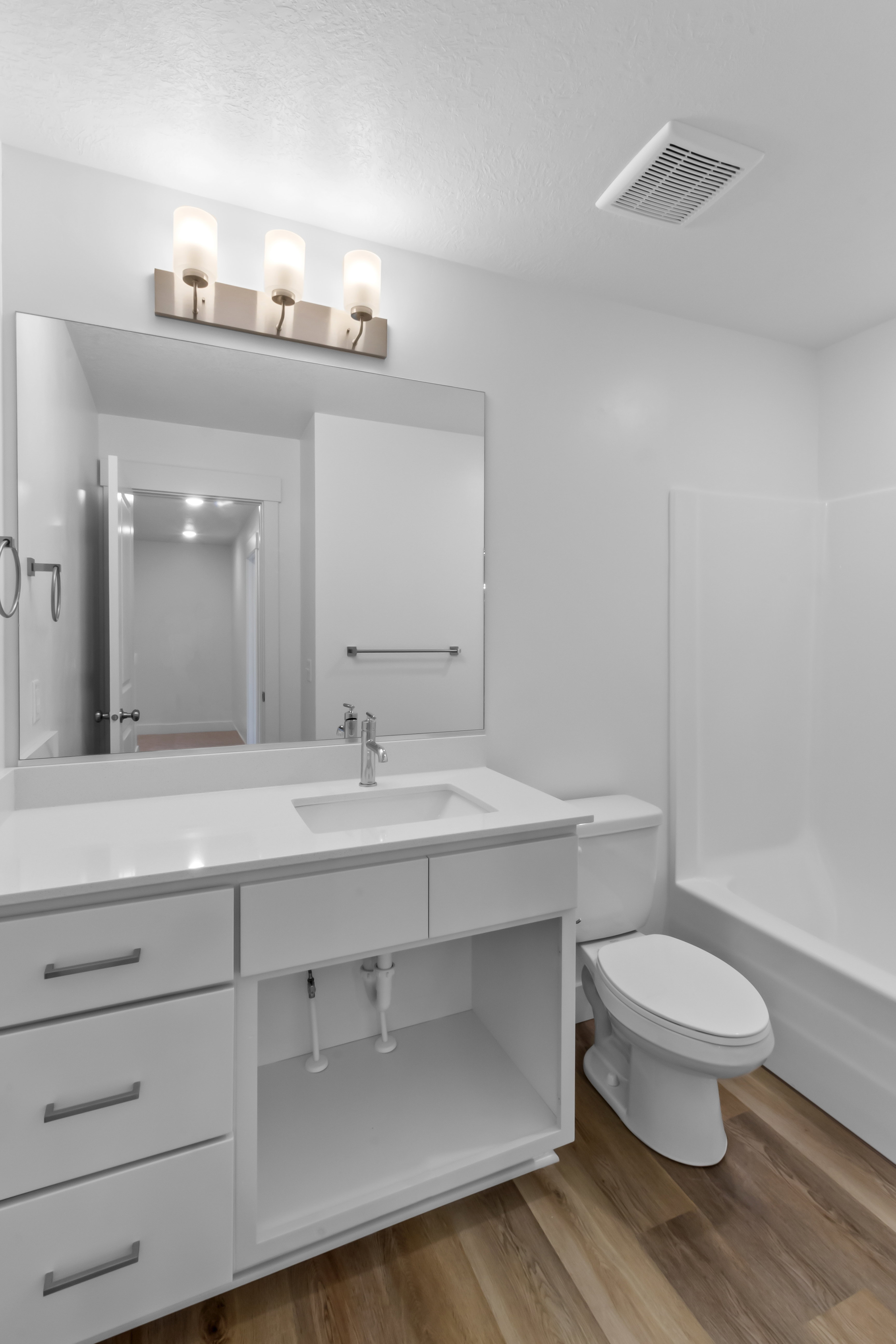 Bathroom featuring a single vanity with an integrated sink, white cabinetry, and a light-toned countertop