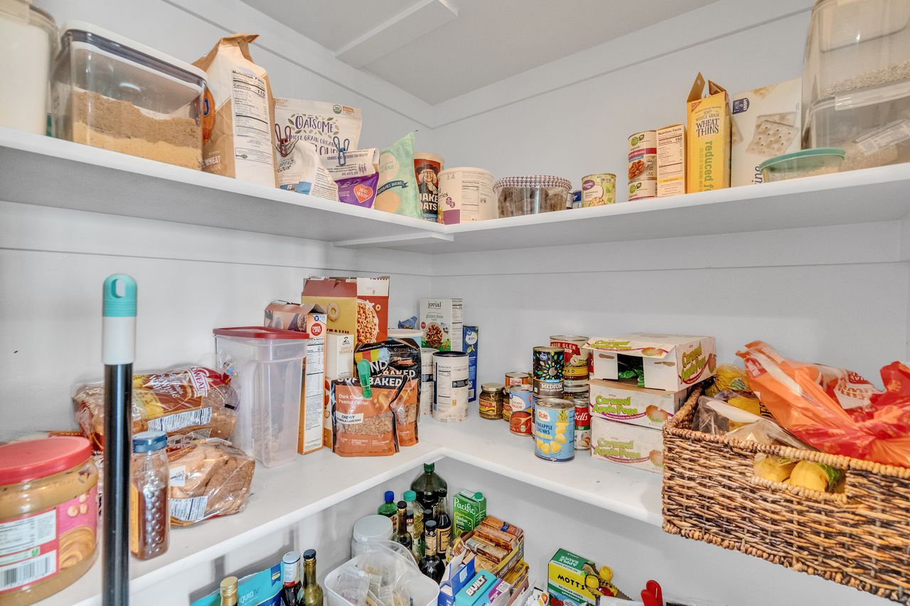 Built-in pantry shelving featuring white finishes and a corner configuration