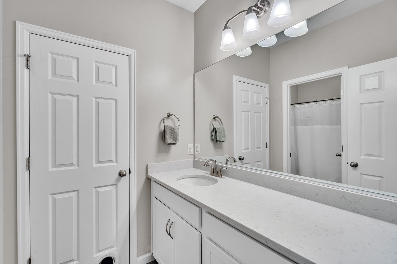 Bathroom vanity featuring an integrated sink, brushed nickel faucet, and a light-toned countertop