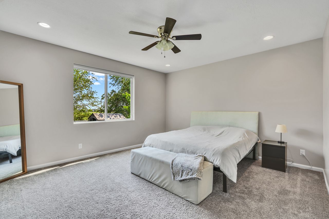 Carpeted room with a large window, recessed lighting, and a ceiling fan