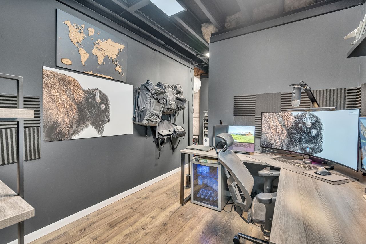 Dedicated workspace featuring wood-finish flooring and dark-toned walls