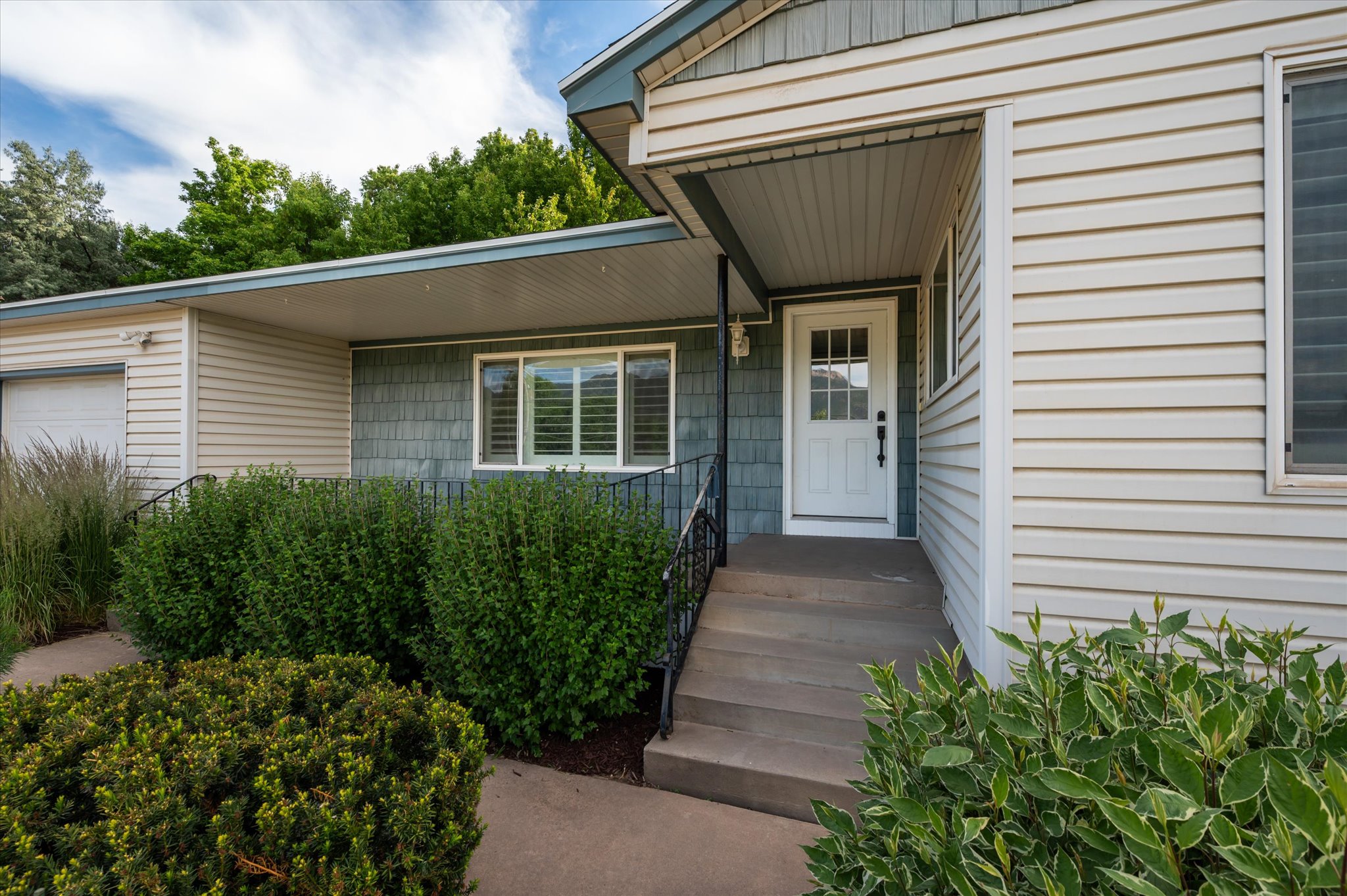 Entryway featuring a white paneled door with windowpanes, dark hardware, and a covered porch