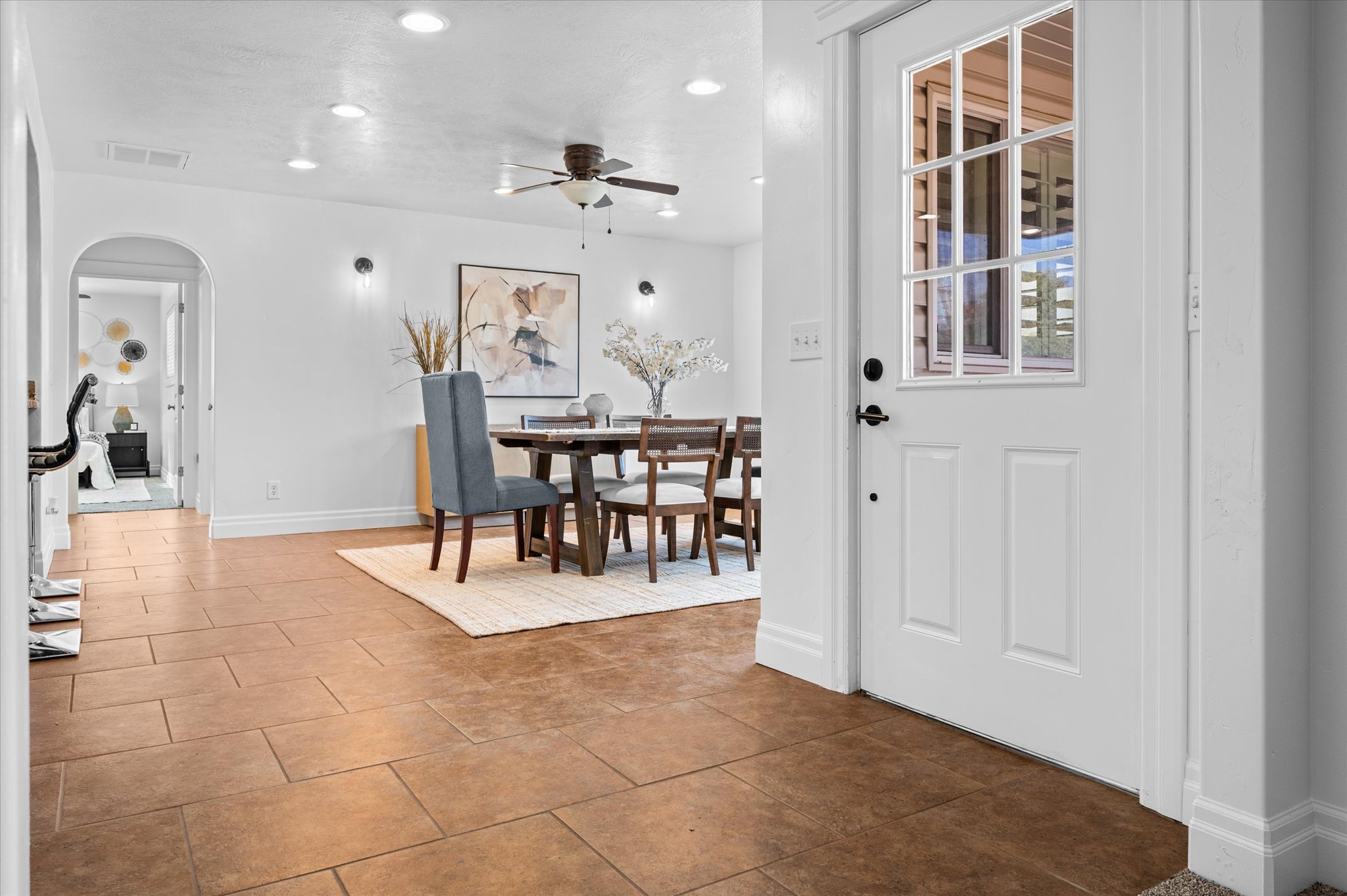 Entryway featuring rectangular floor tiles and a paneled door with divided lite glass