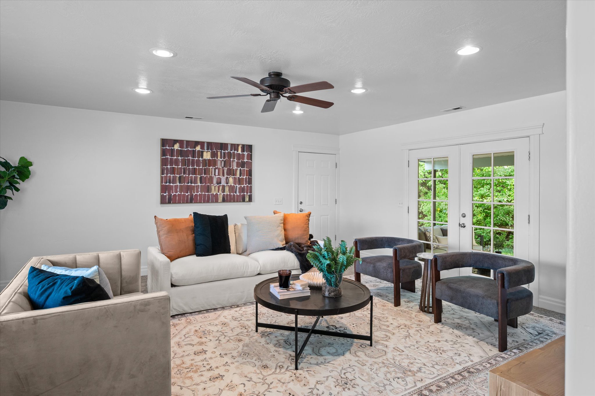 Bright living area featuring recessed lighting, a ceiling fan, and French doors leading to exterior space