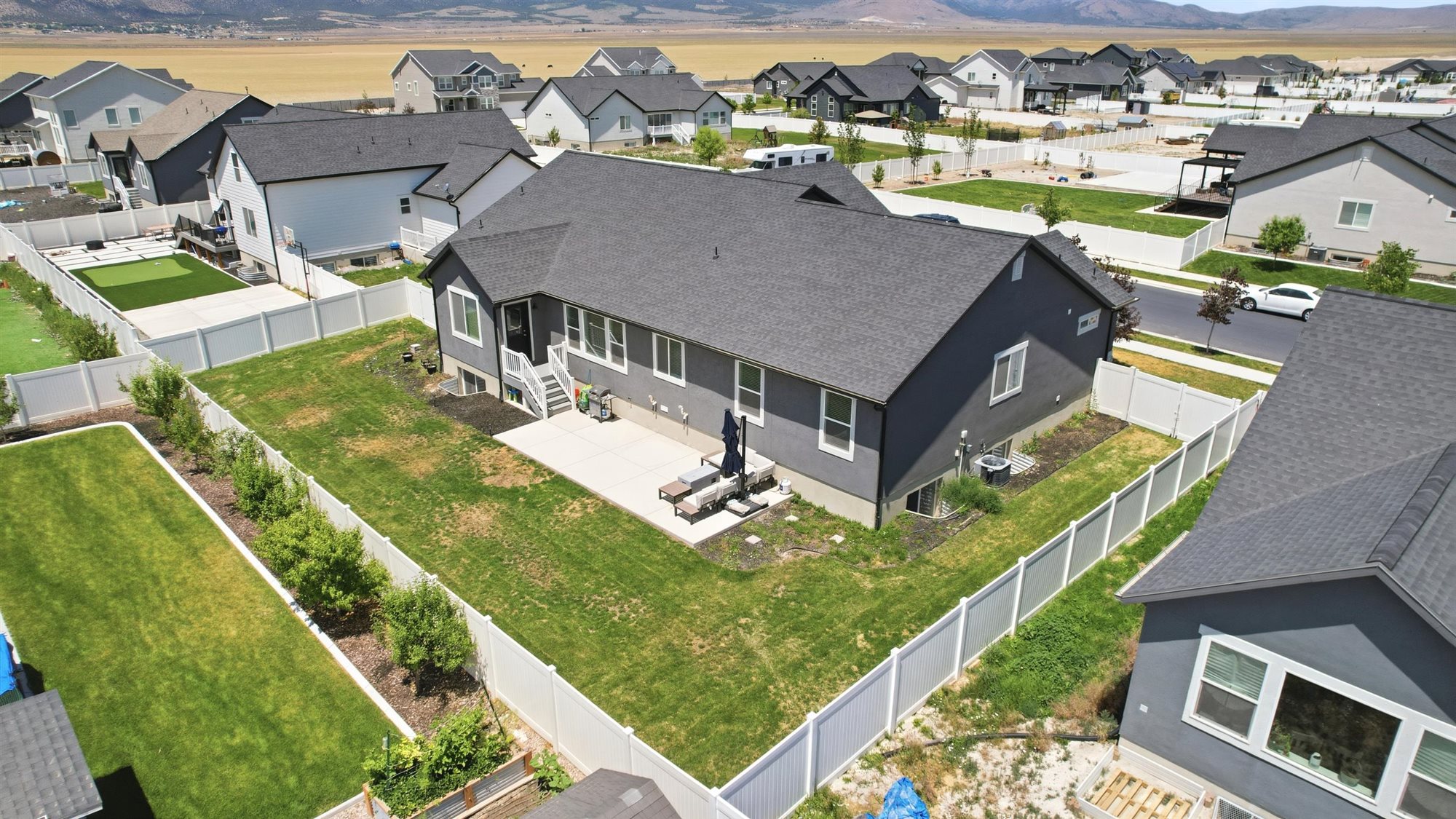 Private backyard featuring a concrete patio, perimeter fencing, and mature landscaping