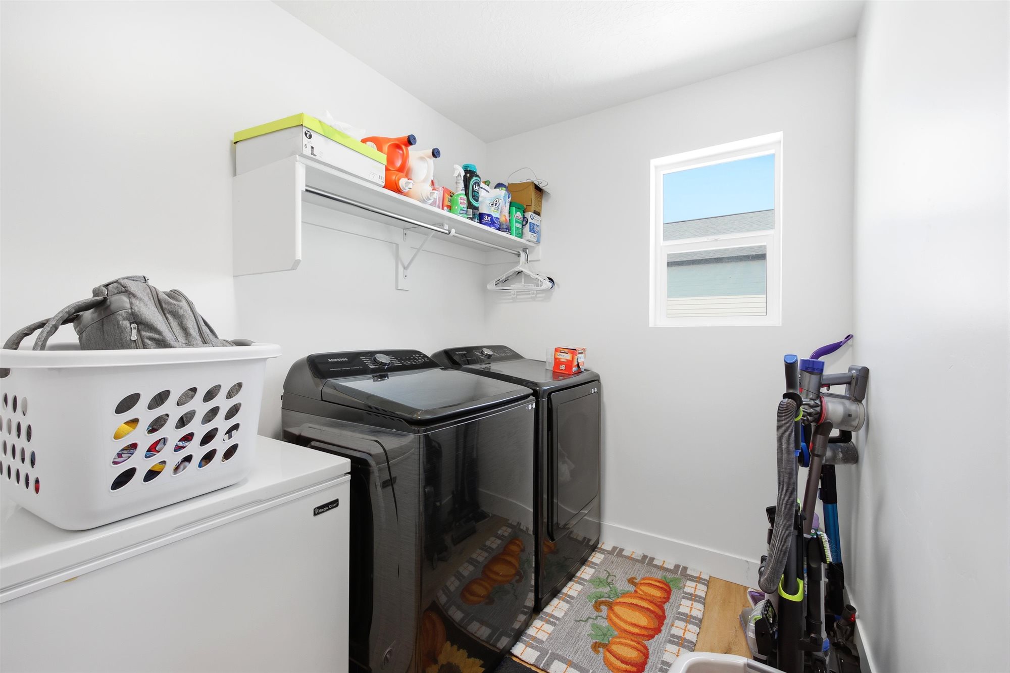 Dedicated laundry area featuring white walls and a single window for natural light