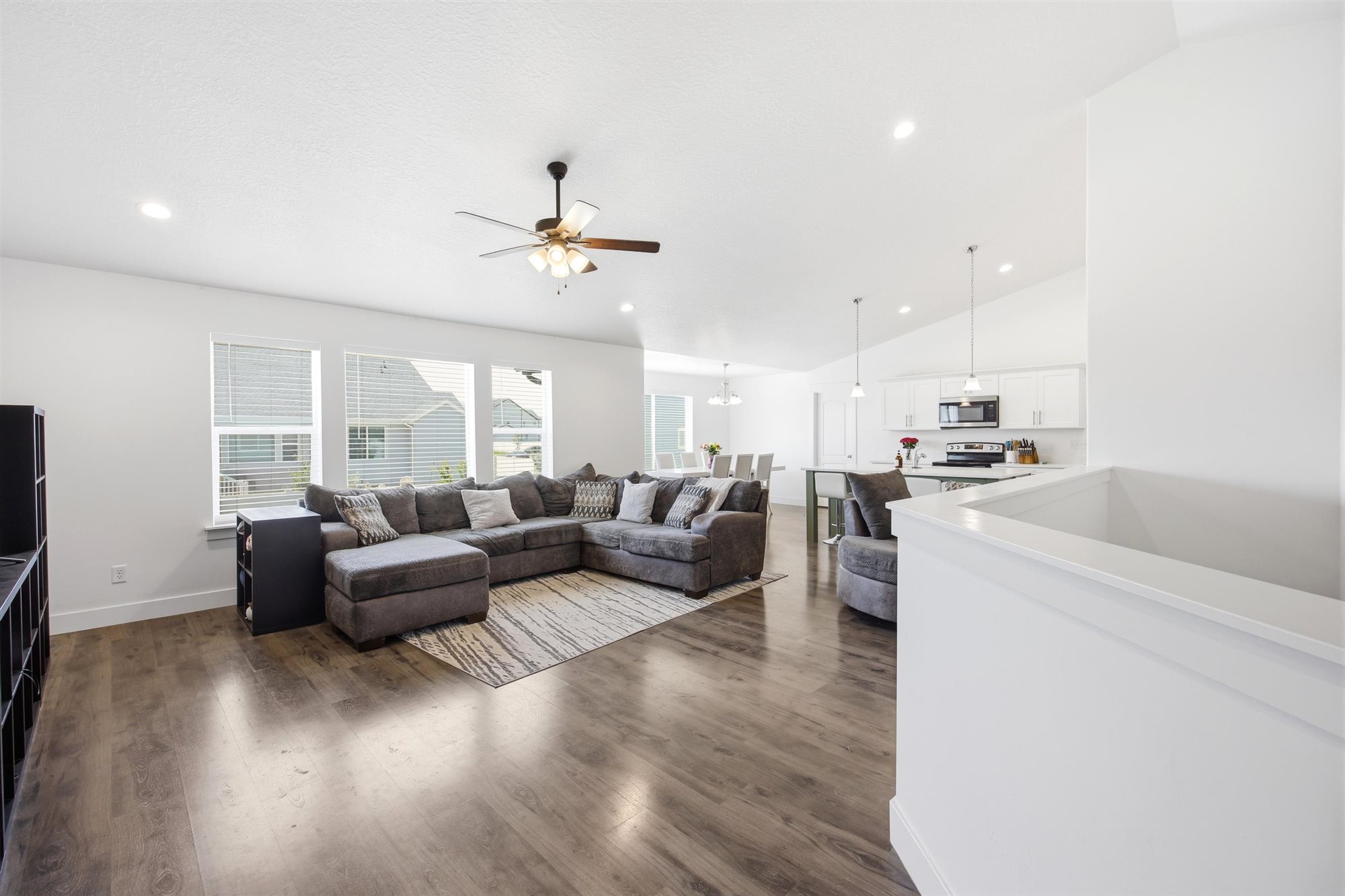 Open-concept living space featuring wood-finish flooring, recessed lighting, and a ceiling fan