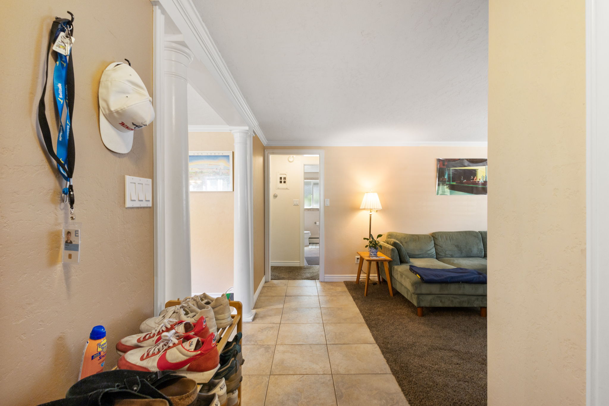 Entryway featuring tile flooring and an arched doorway opening to a carpeted living area