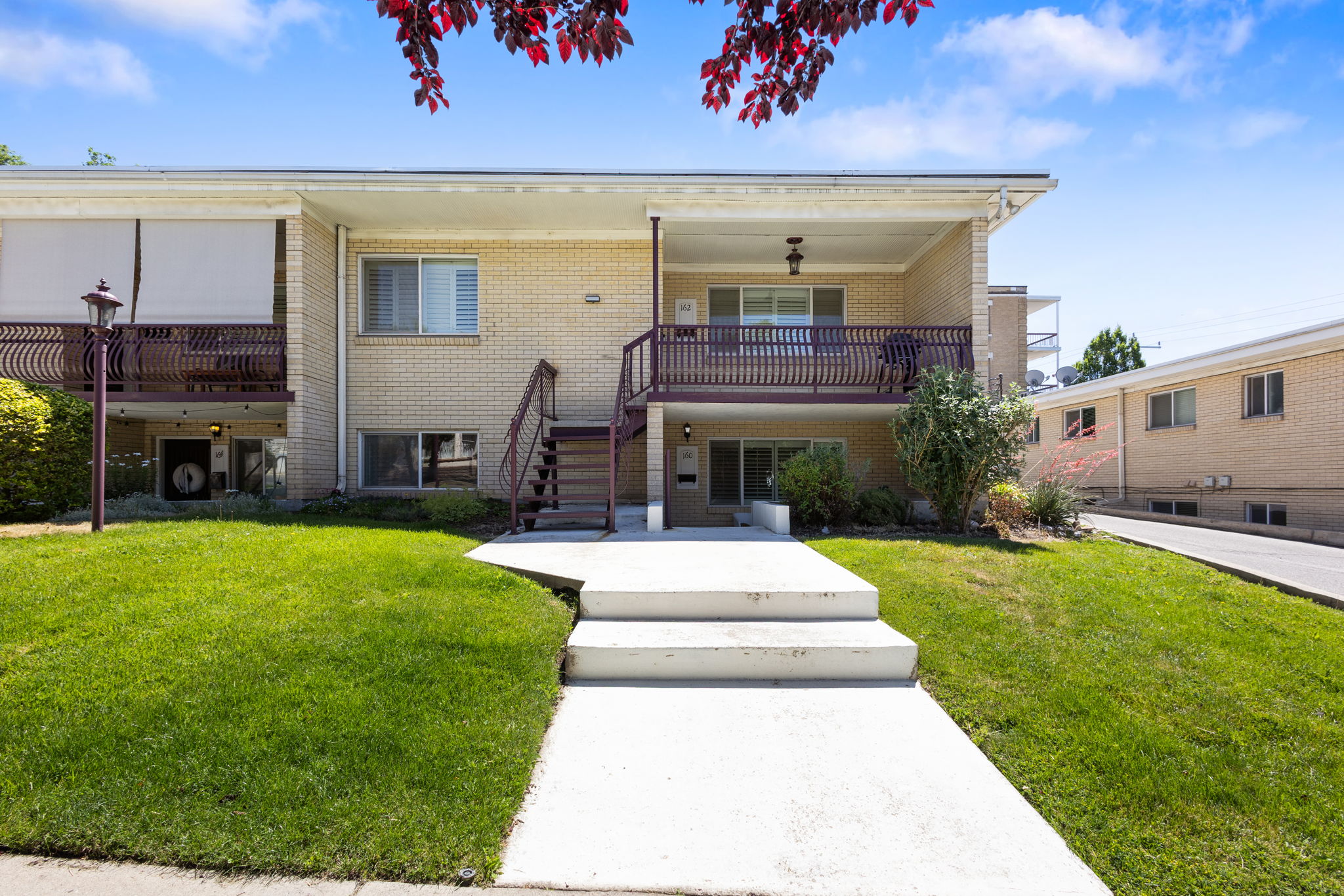 Brick exterior with a covered upper balcony featuring decorative metal railings