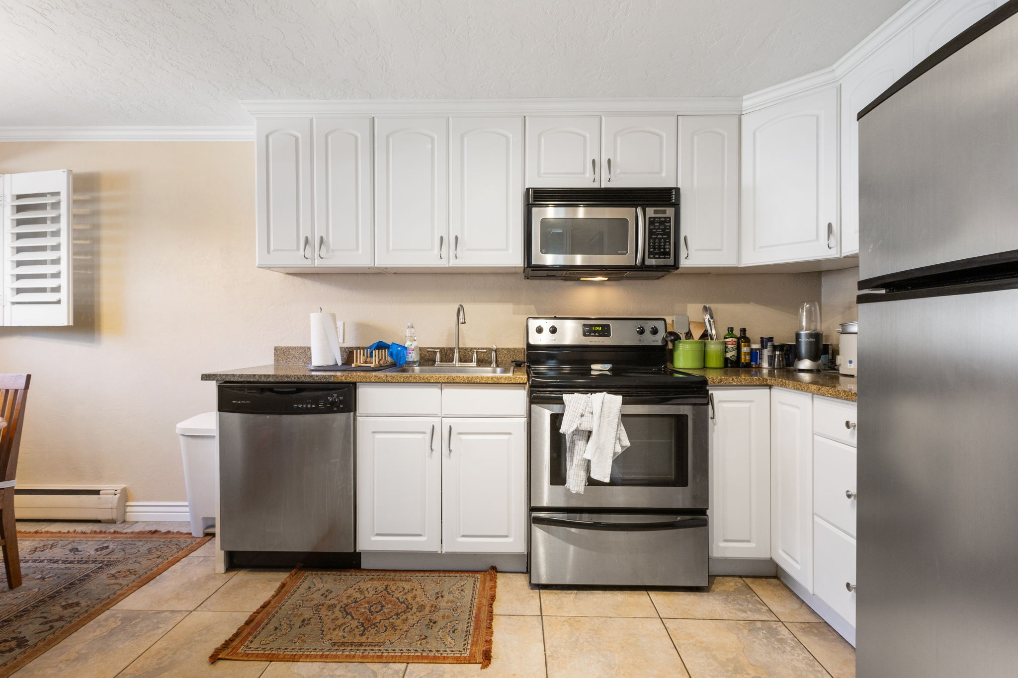 Kitchen featuring white cabinetry, stone-finish countertops, and stainless steel appliances