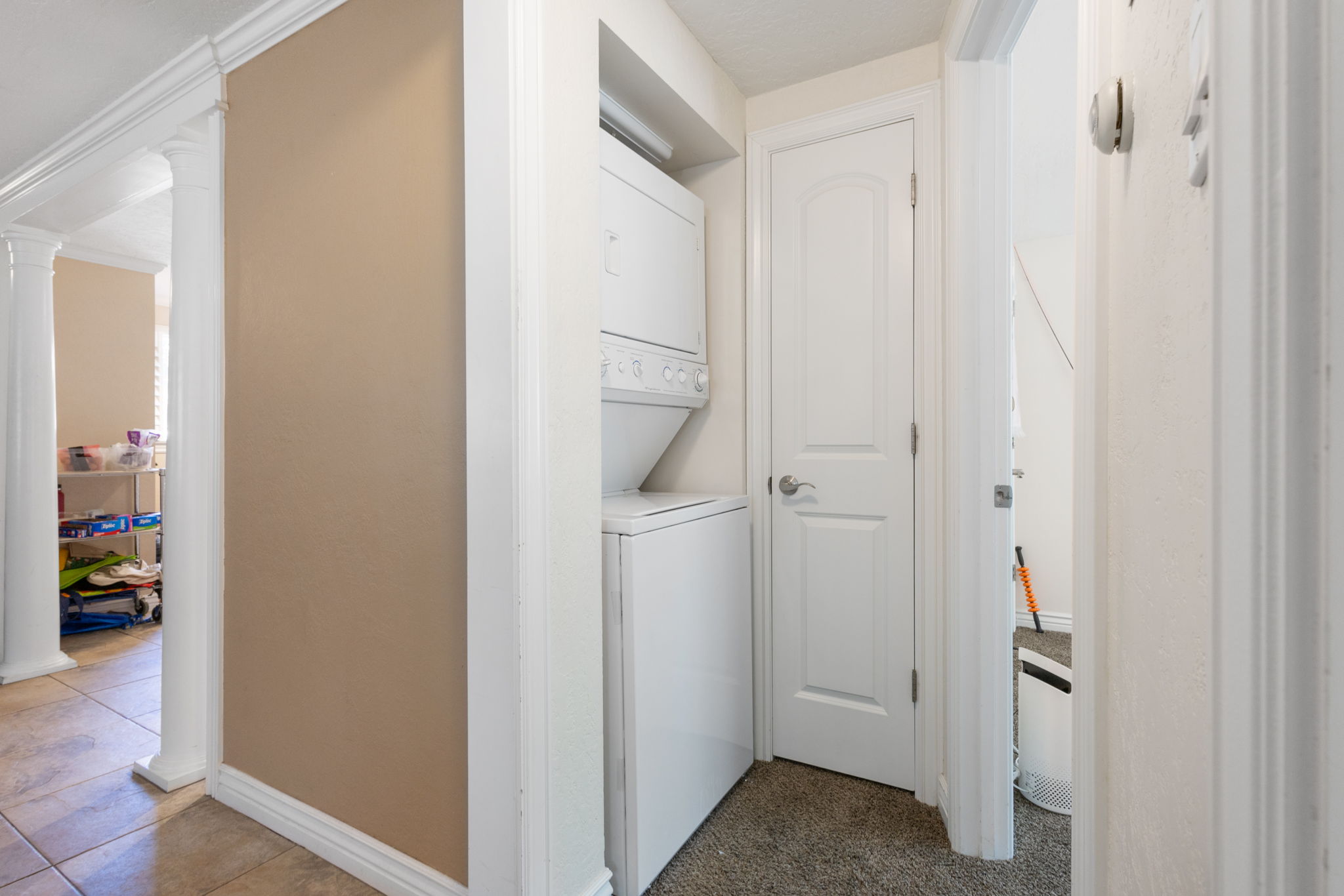 Dedicated laundry area featuring a stacked washer and dryer unit