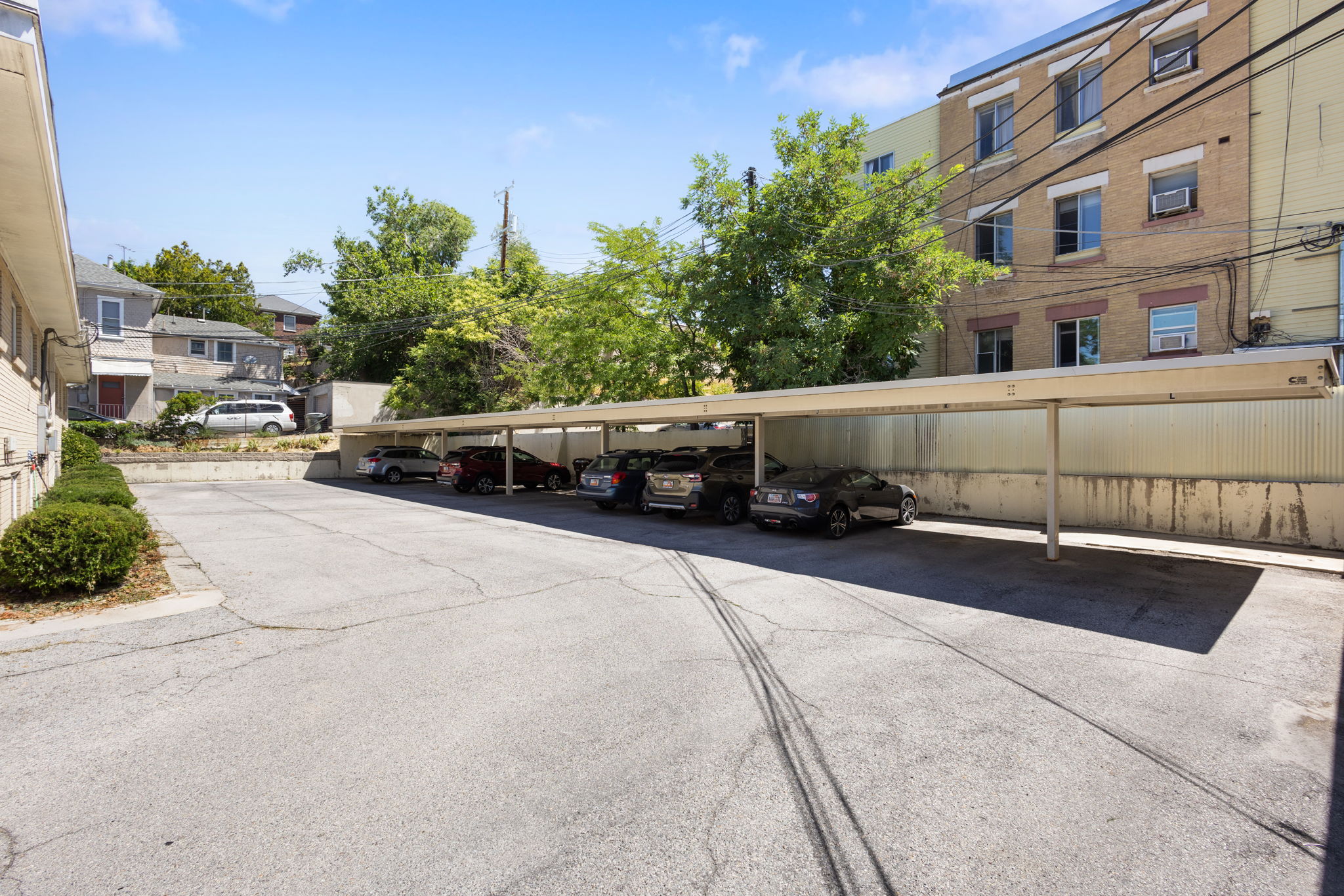Paved parking area with a covered carport structure providing sheltered parking spaces