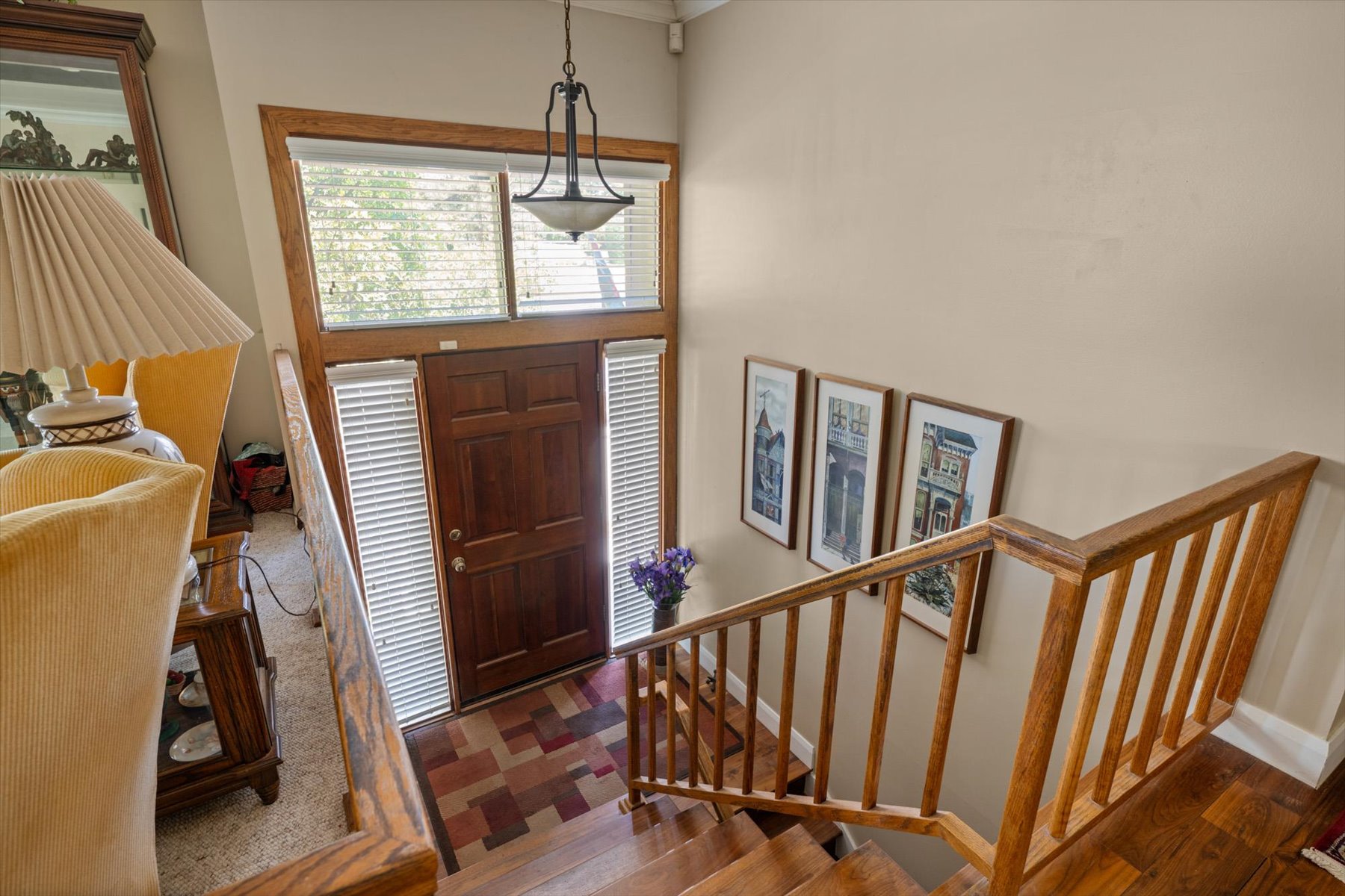 Vaulted entryway with a dark wood door, sidelights, and transom window