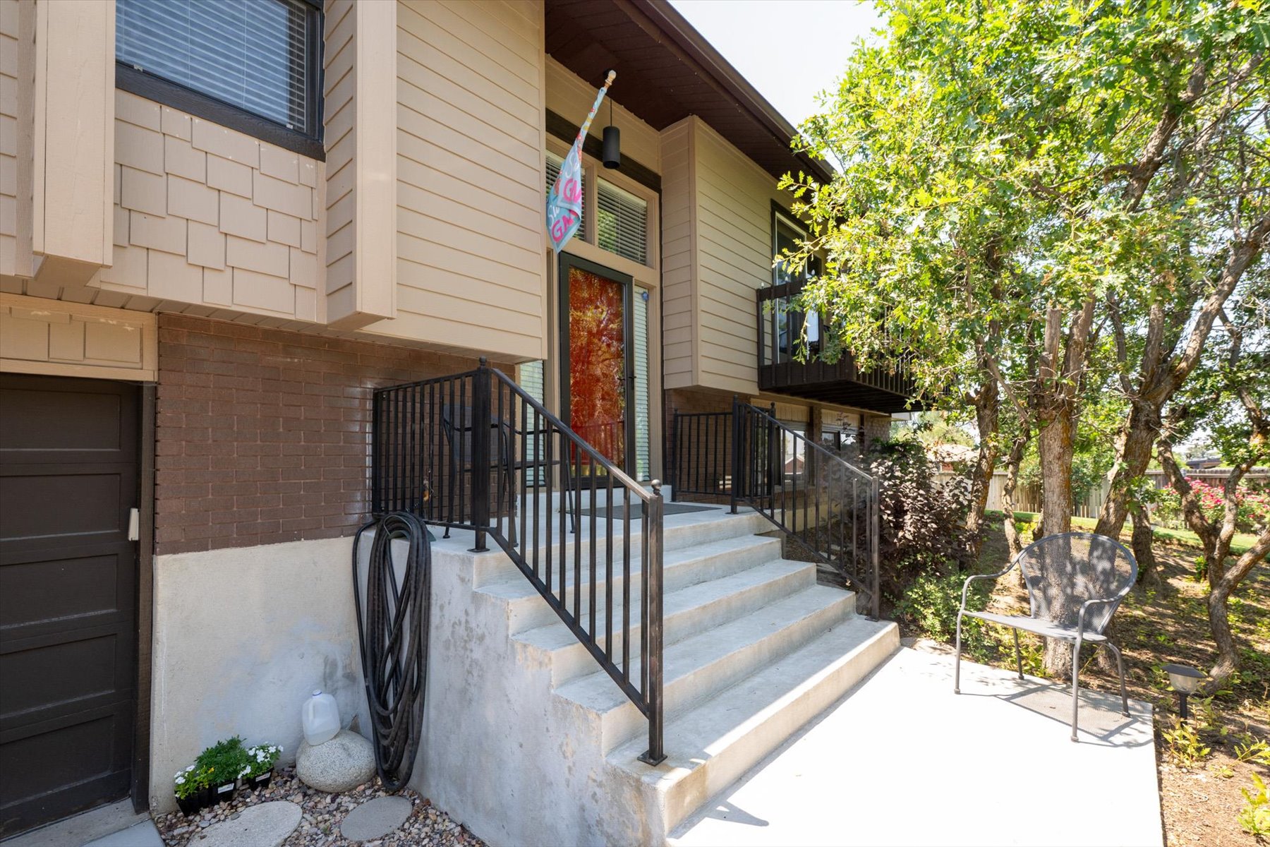 Multi-level exterior with tan siding and brick accents