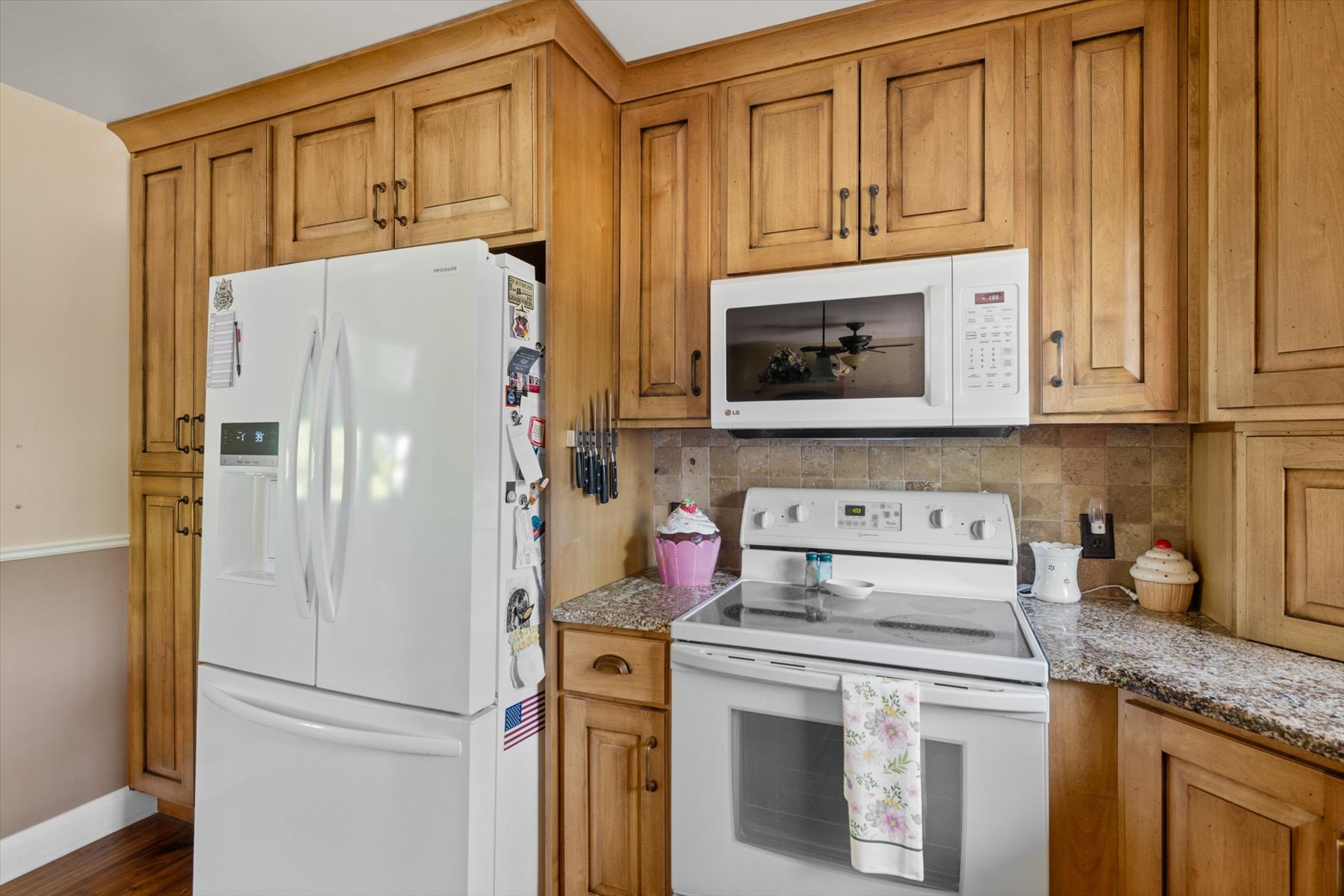Kitchen featuring wood cabinetry, granite-finish countertops, and a tile backsplash