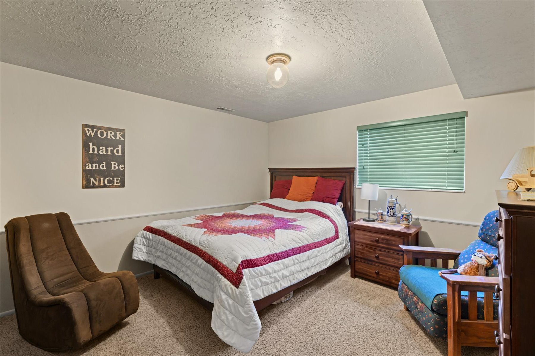 Carpeted room featuring a window with horizontal blinds, a ceiling-mounted light fixture, and a chair rail molding