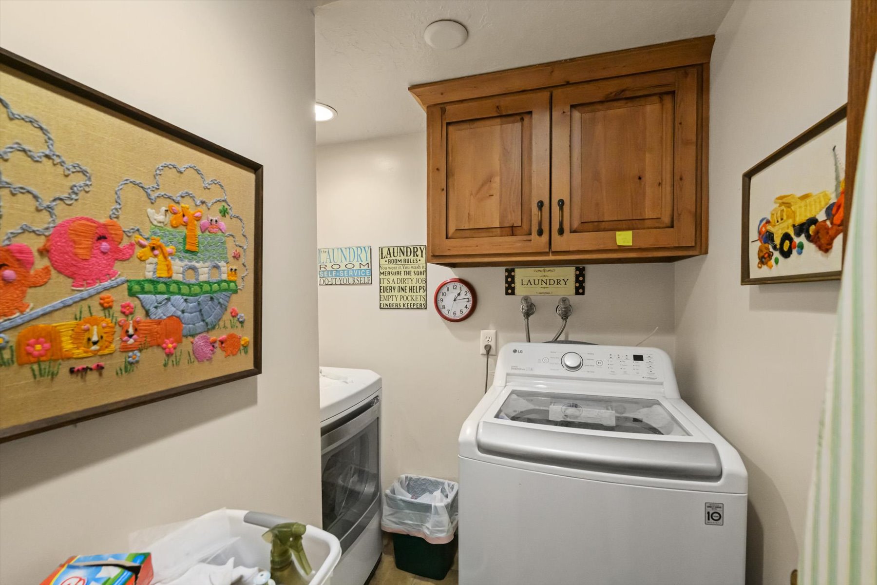 Dedicated laundry area featuring overhead wood cabinetry for storage, white walls, and recessed lighting