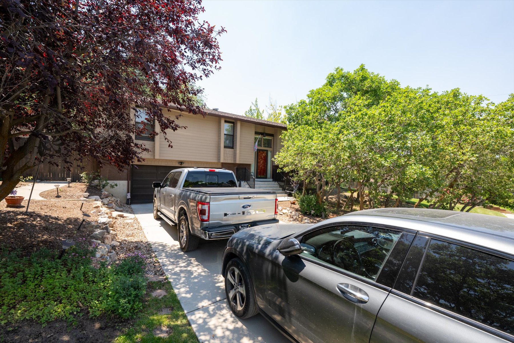 Split-level residence featuring a two-car garage and a concrete driveway