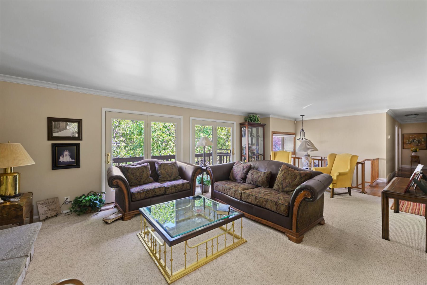 Living room featuring light-toned carpeting, neutral wall colors, and crown molding