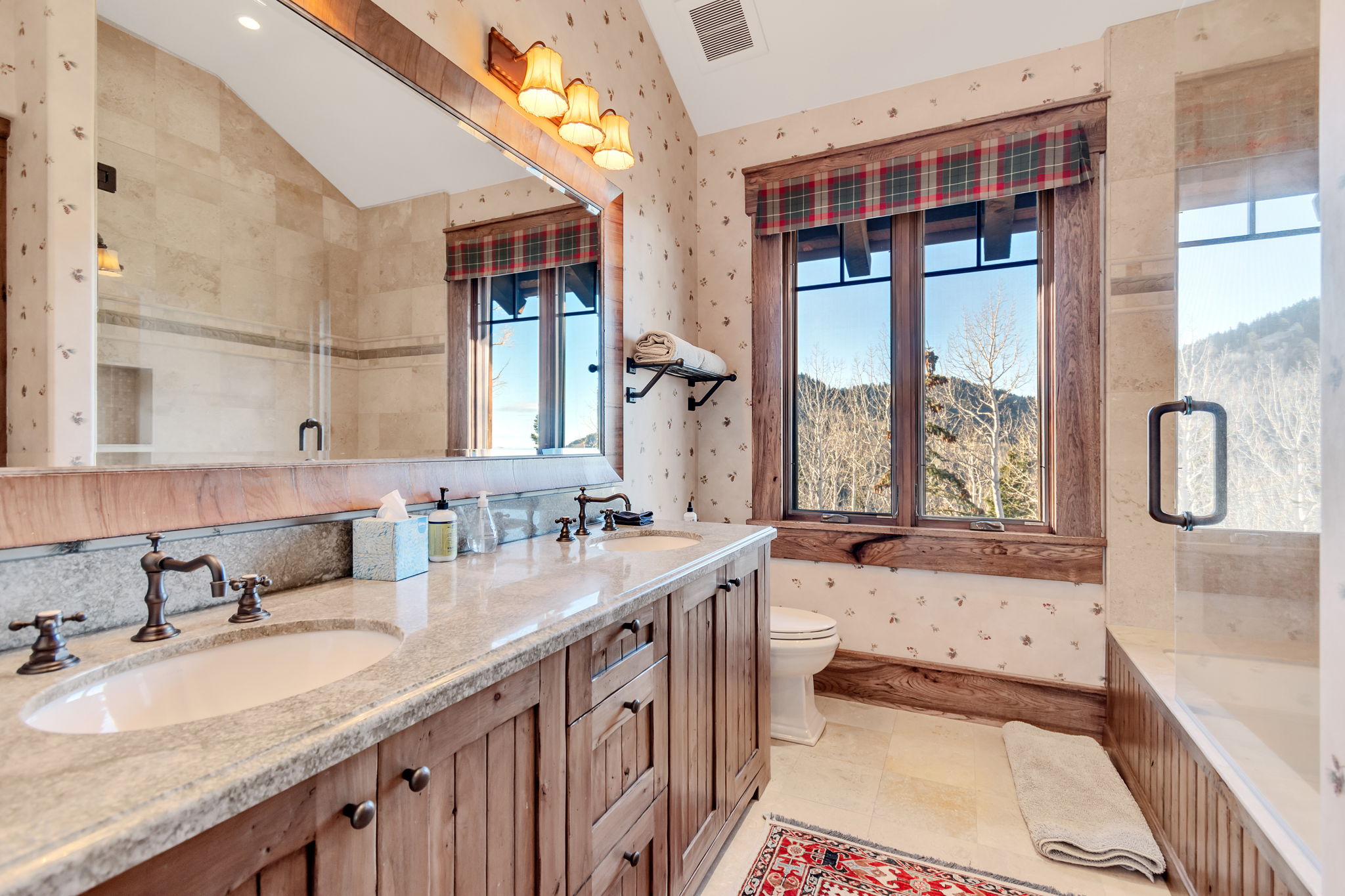 Double vanity with integrated sinks, light-toned stone countertop, and bronze-finish hardware