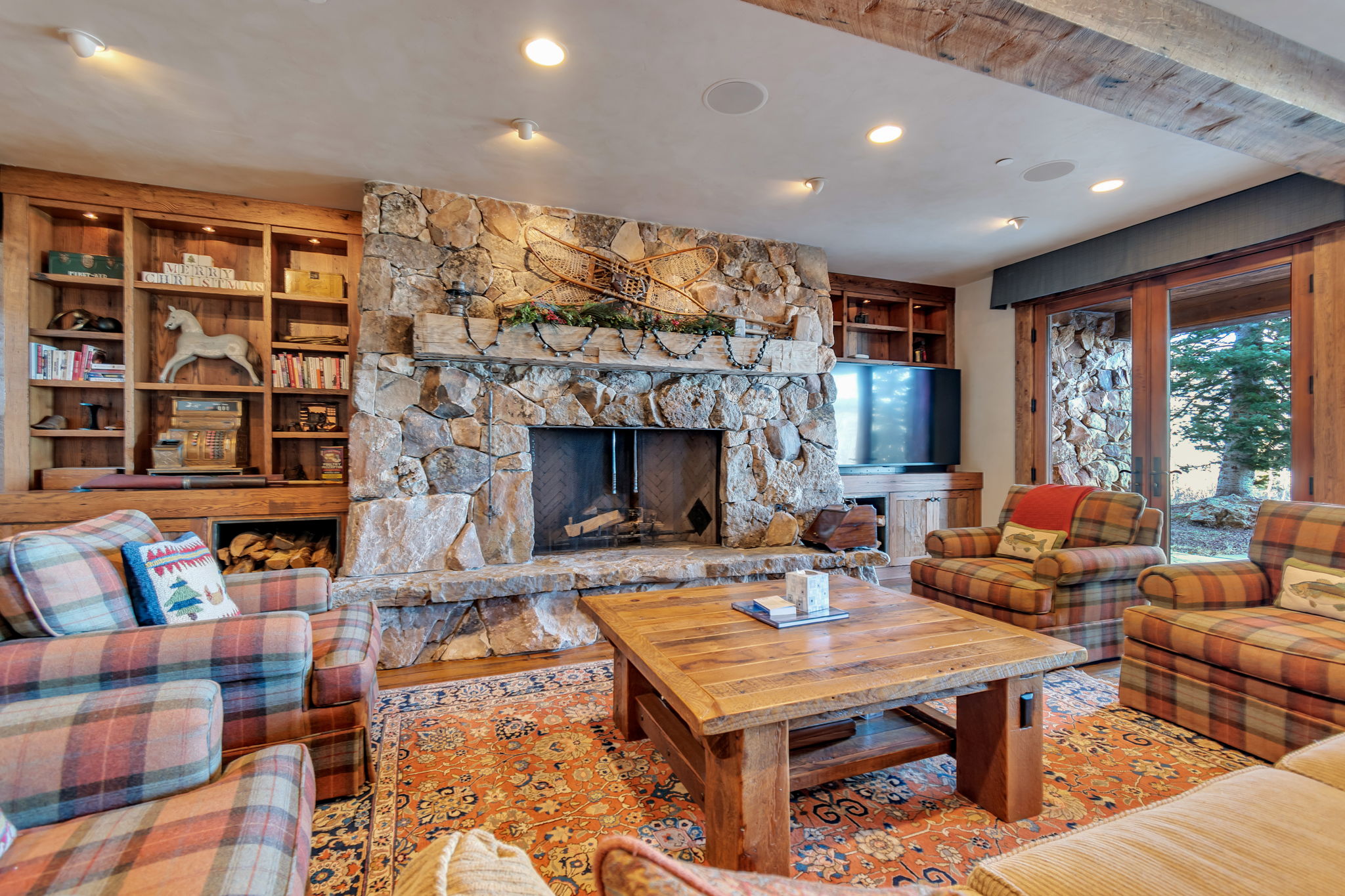 Stone fireplace with a hearth, flanked by built-in wood shelving