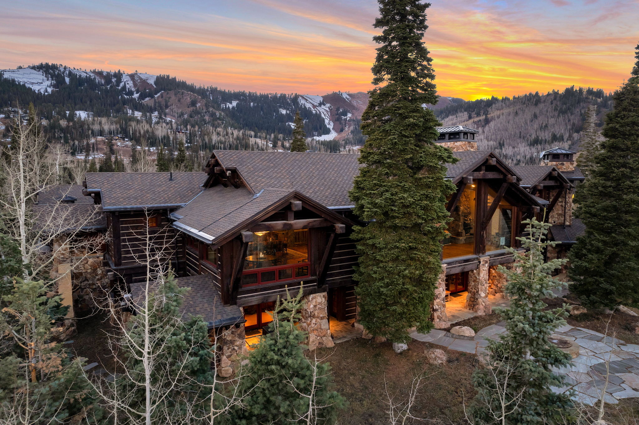 Expansive log and stone residence featuring a multi-gabled roofline
