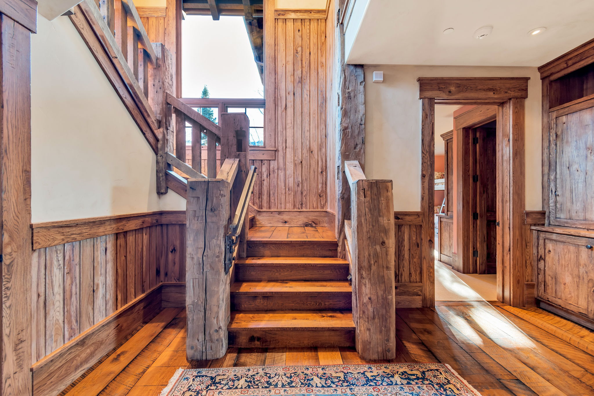 Wood-finish staircase featuring a substantial newel post