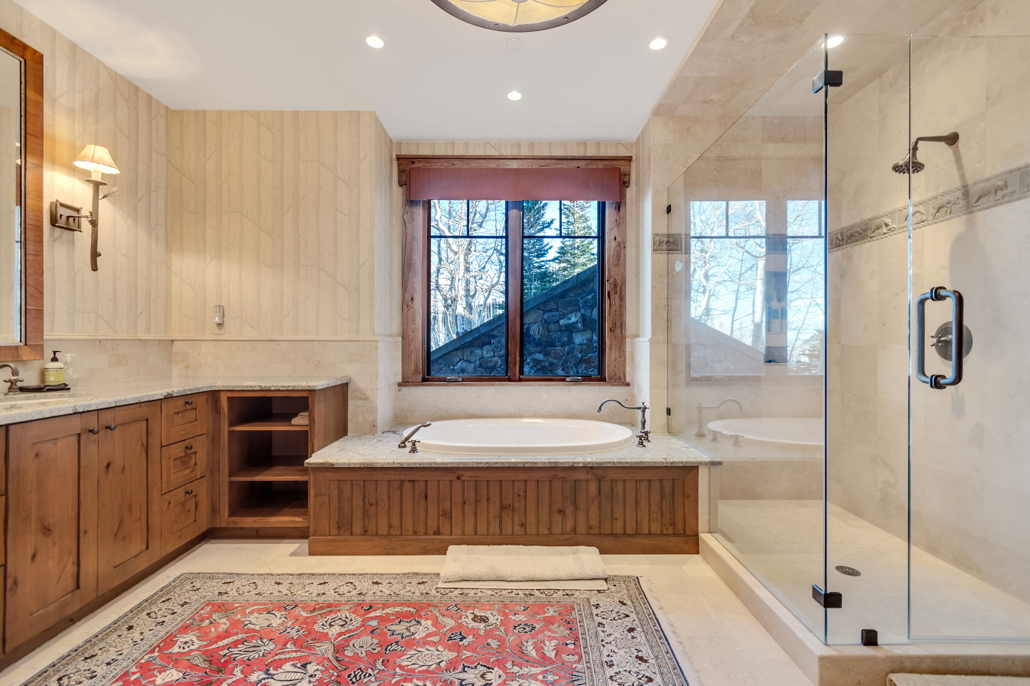Bathroom featuring an integrated soaking tub, clear glass shower enclosure, custom wood cabinetry, stone countertops, and recessed lighting