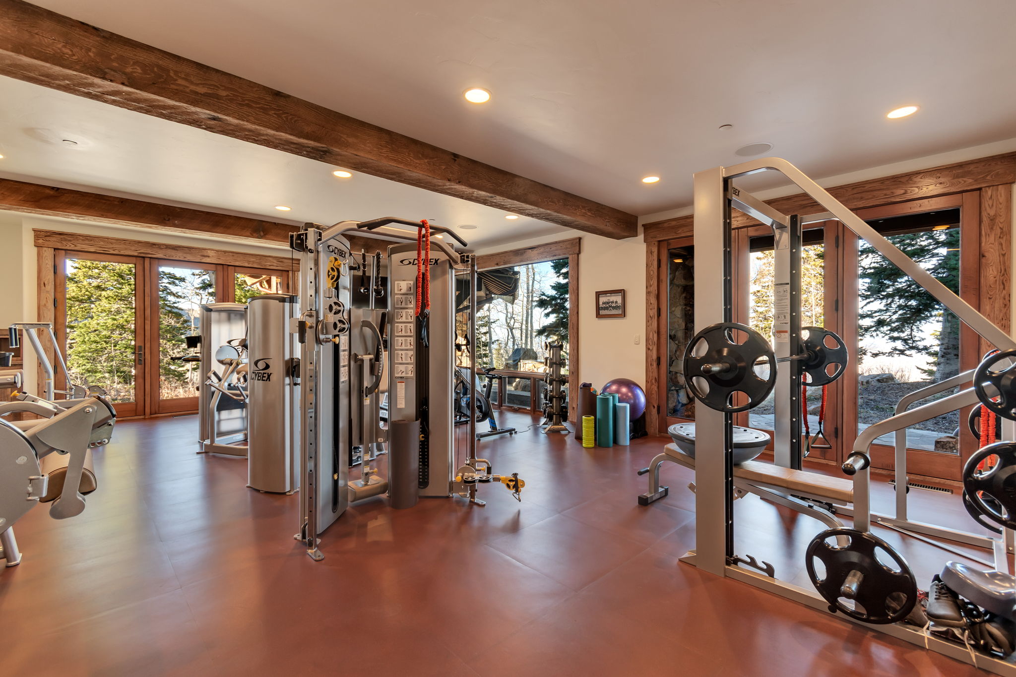Dedicated fitness space featuring wood-finish flooring and exposed timber beams