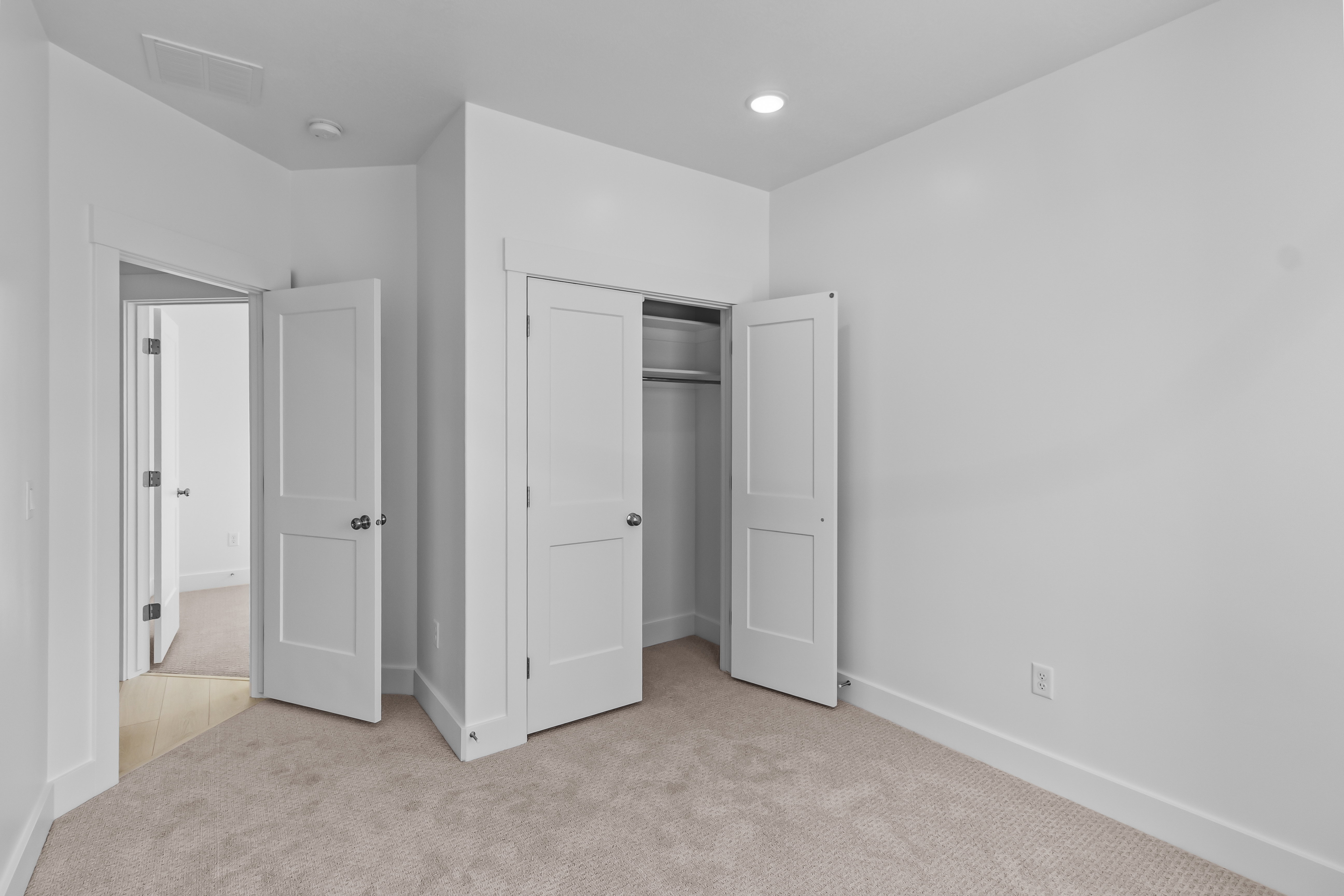 Carpeted room with white walls, recessed lighting, and white trim