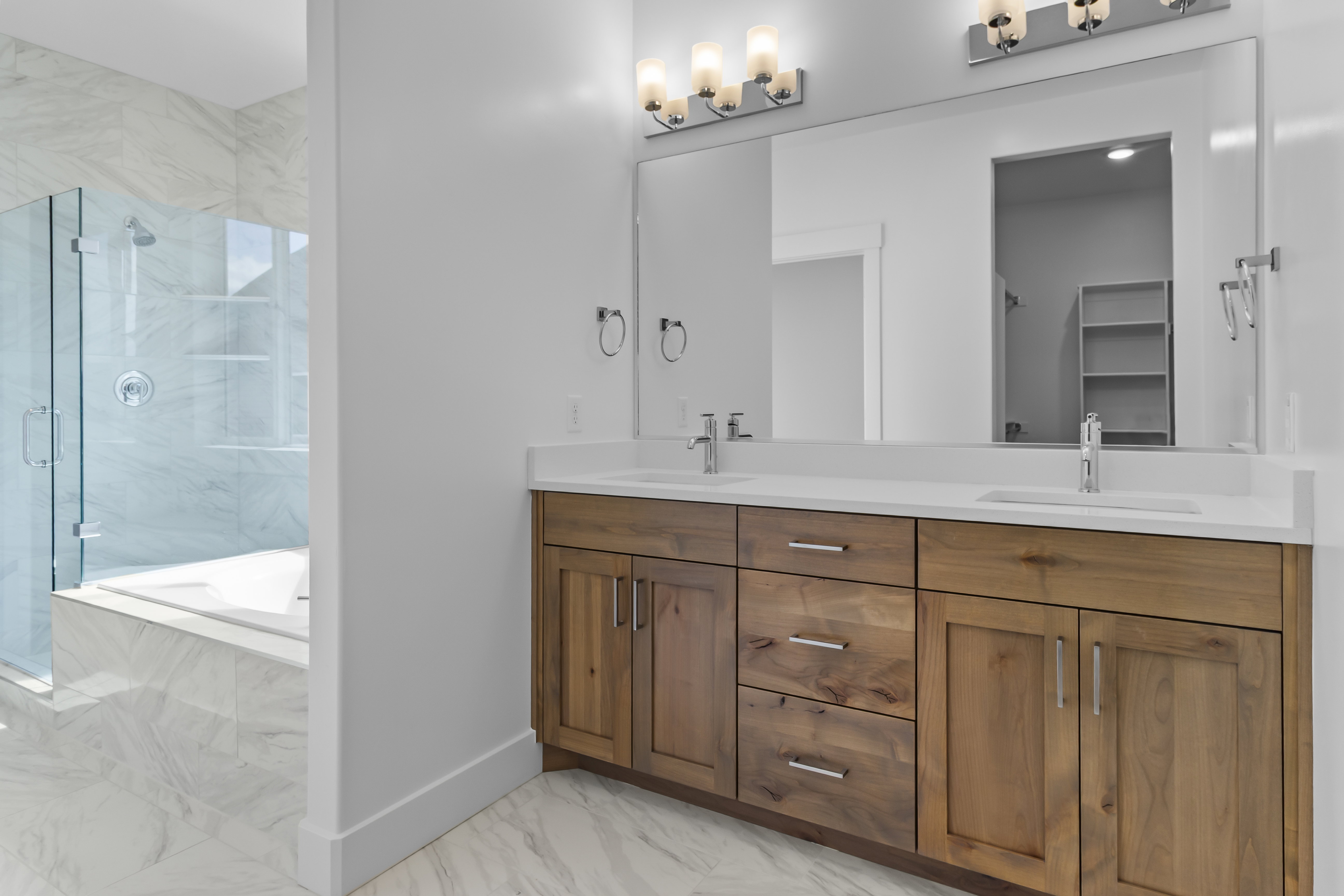 Double vanity featuring wood-finish cabinetry and white countertops