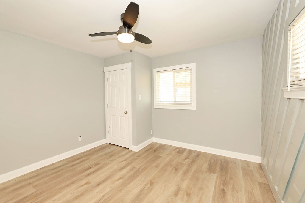 Interior space featuring light-toned walls, wood-finish flooring, and white trim