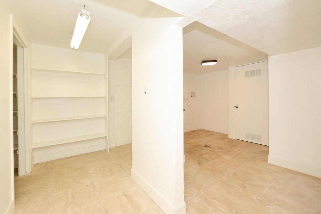 Interior space featuring built-in shelving, tile flooring, and white walls