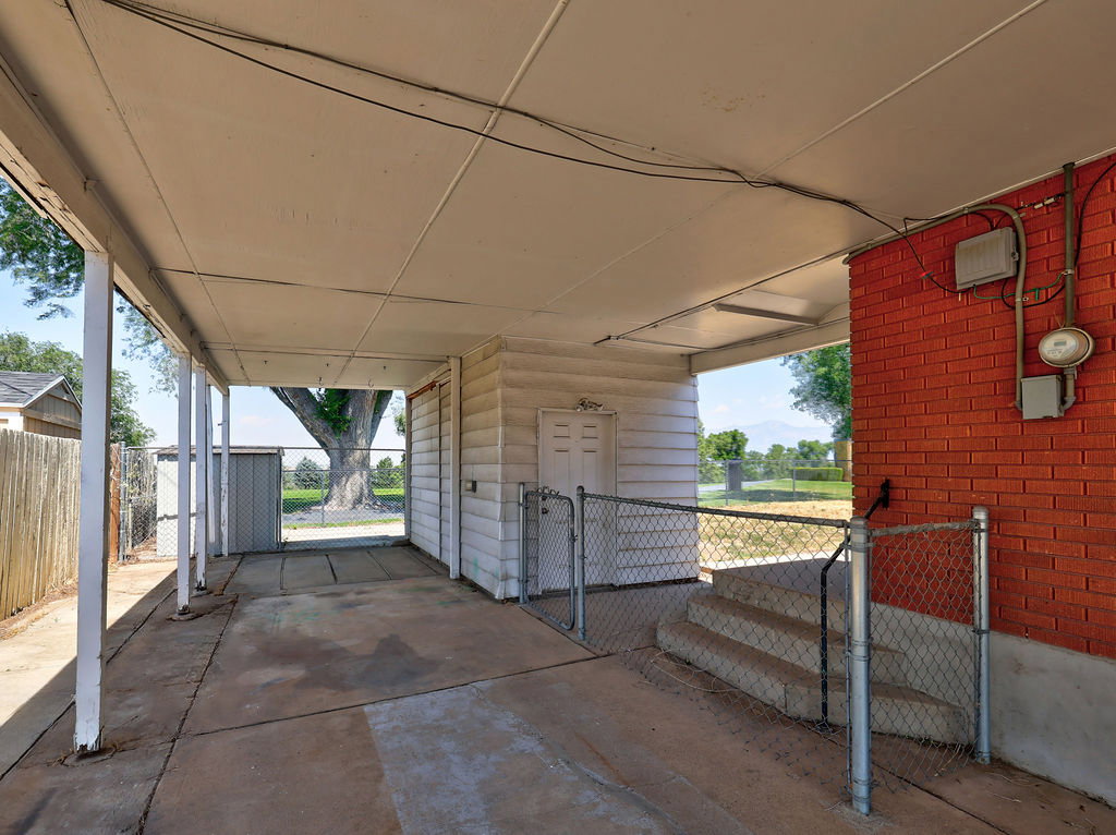 Covered patio area featuring a concrete slab and exposed metal supports