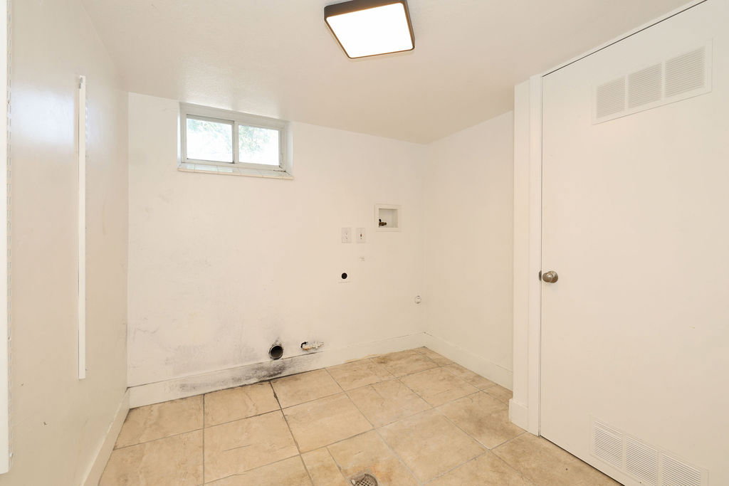 Utility room featuring tiled flooring, a single window, and a white interior door