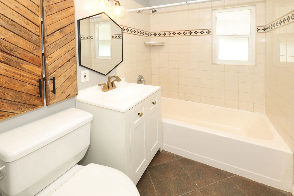 Bathroom featuring a white vanity with a single basin sink, bronze-finish faucet, and coordinating hardware
