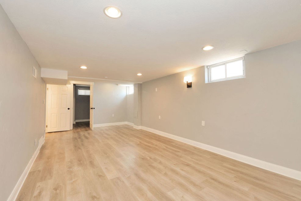Spacious room featuring light wood-finish flooring, recessed lighting, and neutral wall paint