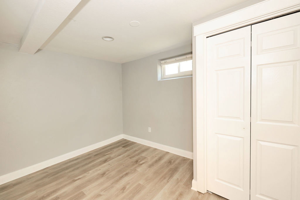 Room featuring wood-finish flooring, recessed lighting, and a window
