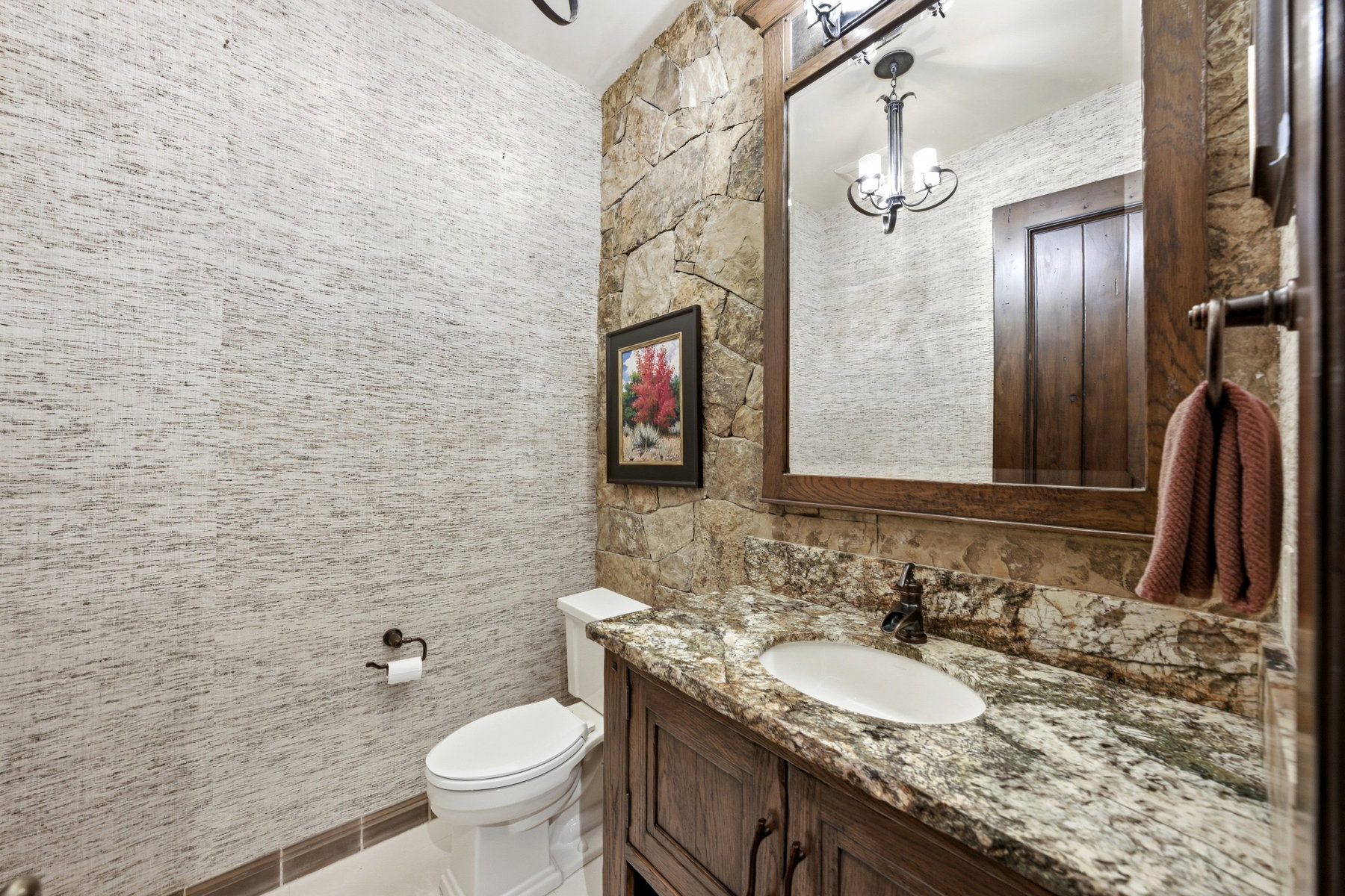 Bathroom vanity with granite countertop, integrated sink, and dark wood-finish cabinetry