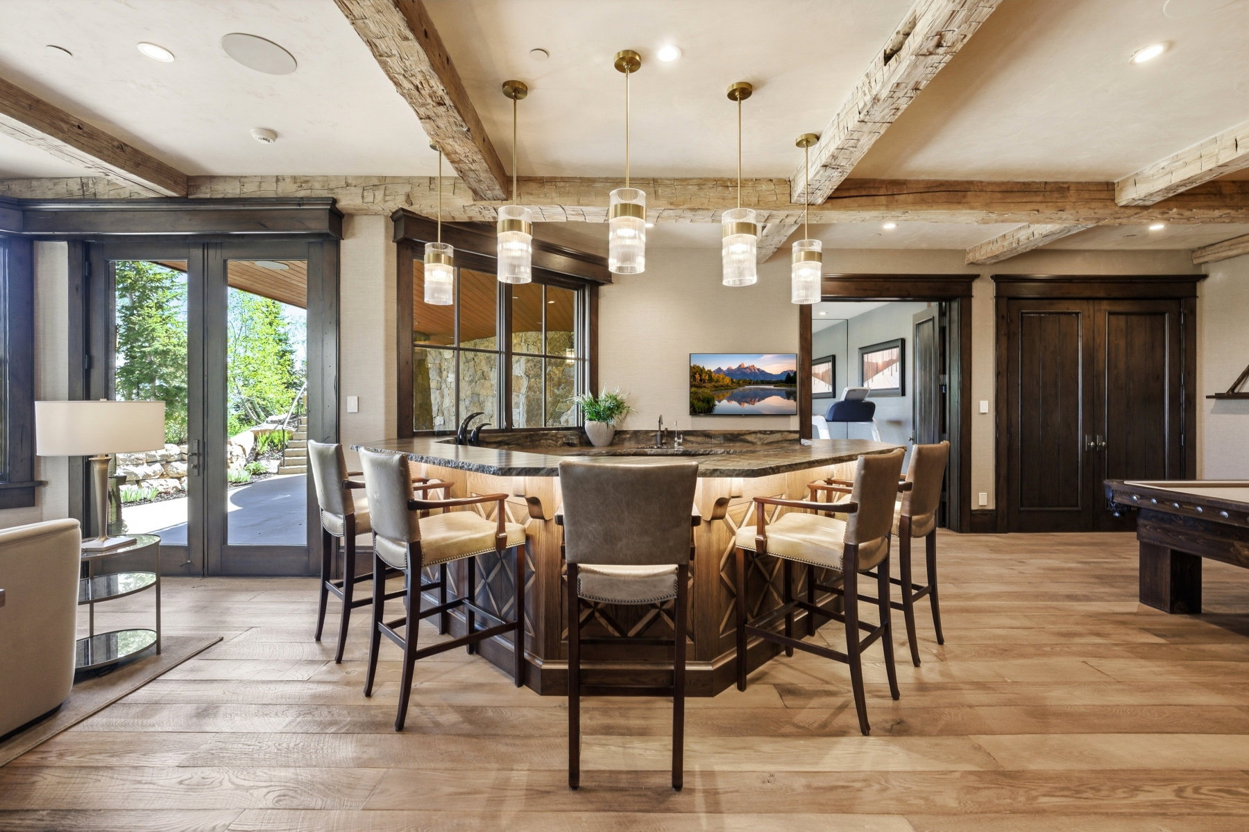 Custom bar area featuring a stone-look countertop, integrated sink, and under-counter lighting